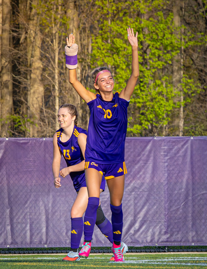 Maya Terryn throws her hands in the air with a big smile, ready to celebrate her goal with her teammates. (Photo by Aibree Akers)