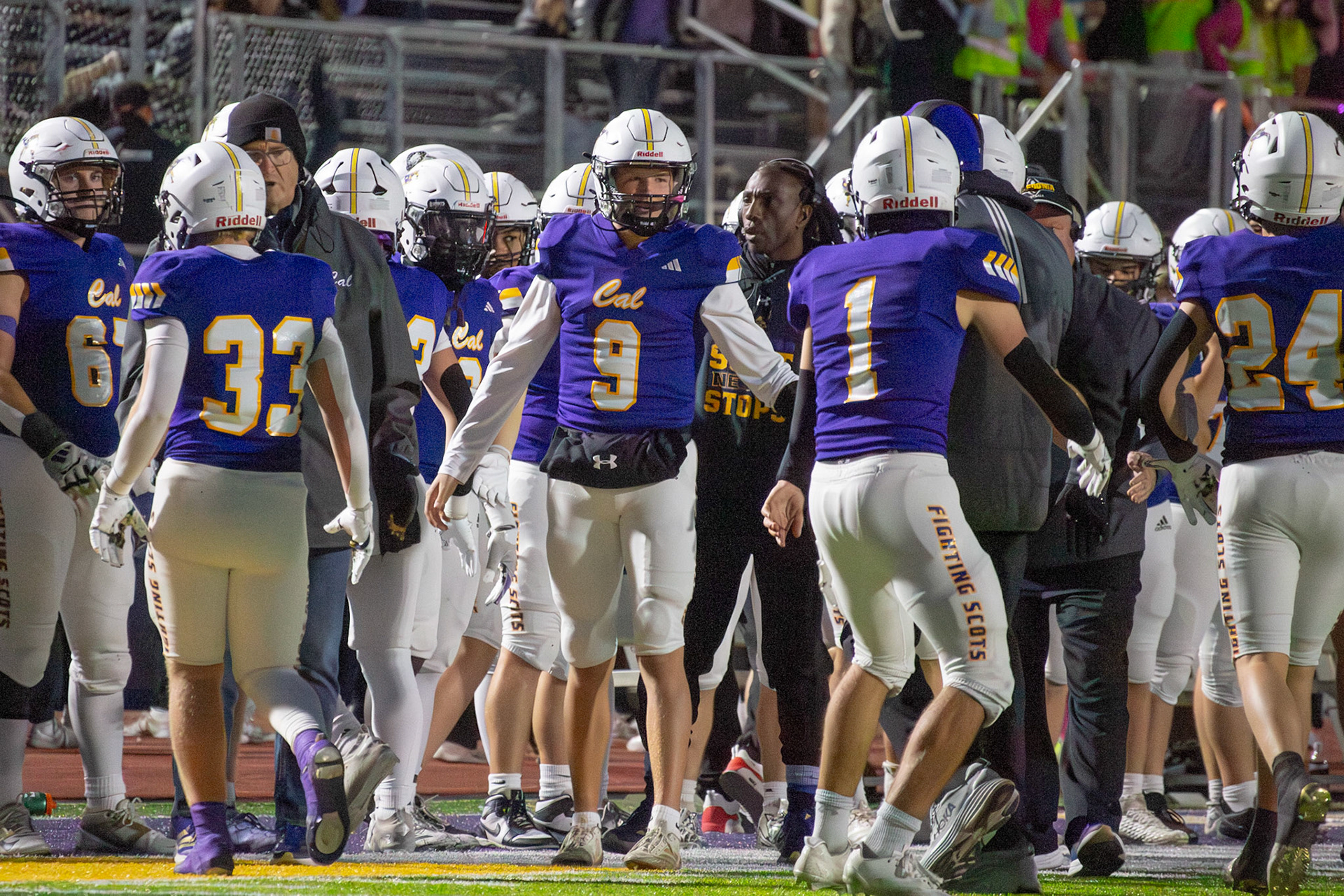 Conlan Schultz and Aaron Collins rally with their teammates before the next drive. (Photo by Egan Otto)