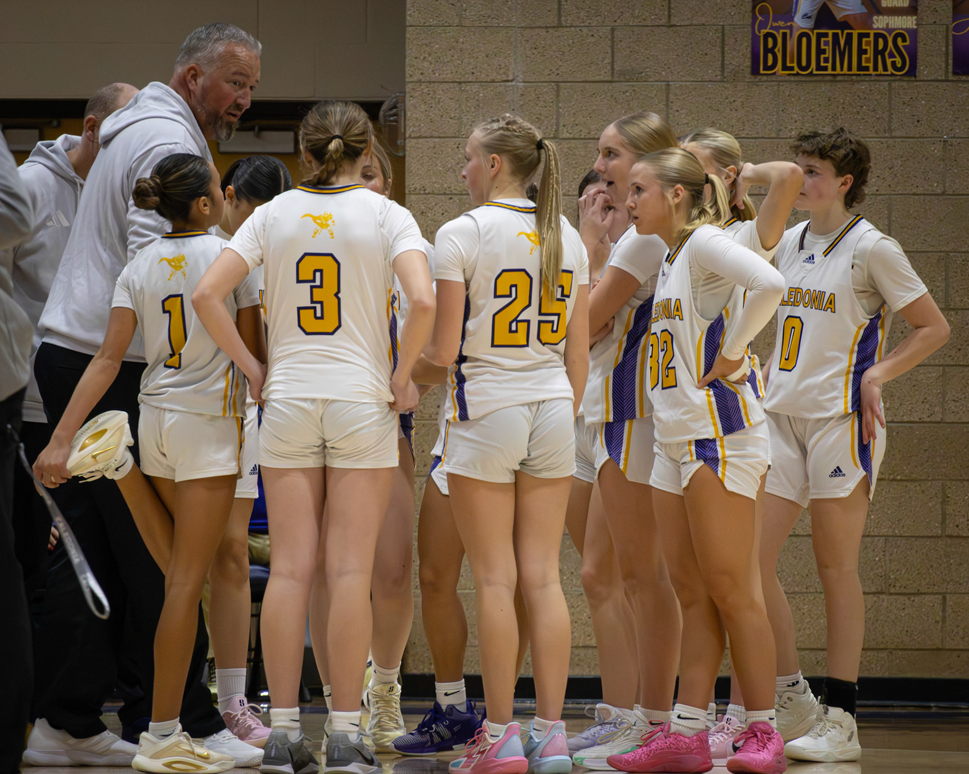 Coach Palmitier takes a moment to refocus, motivate, and prepare the JV girls basketball team as they head into the third quarter, ready to compete together.(Photo by Elise Clarin)