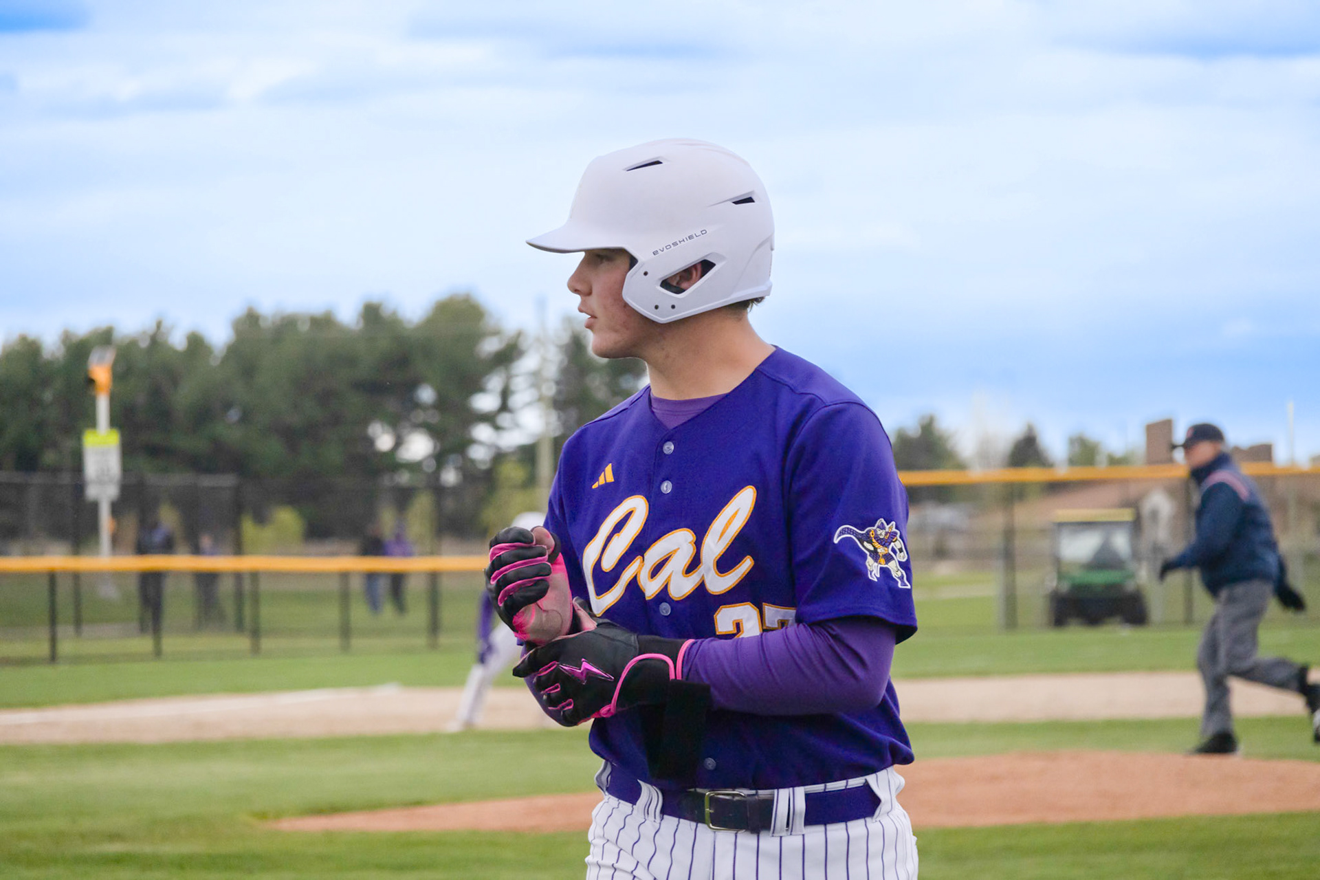 Catching his breath after sprinting to first, Hayden Paggeot changes into his sliding gloves. (Photo by Ella-Grace Wickens)
