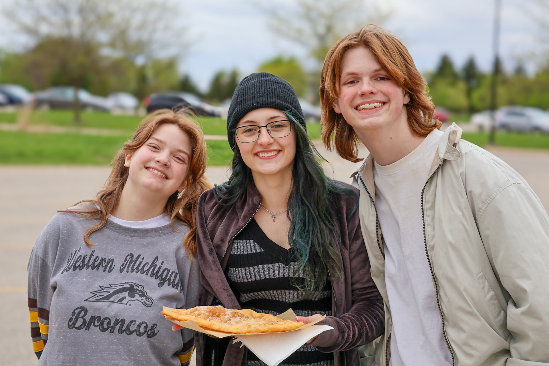 Sharing an elephant ear, seniors Katelyn Jaquish and Andrew VanderKolk, along with junior Maggie Koopman. (Photo by Brianna Severson)