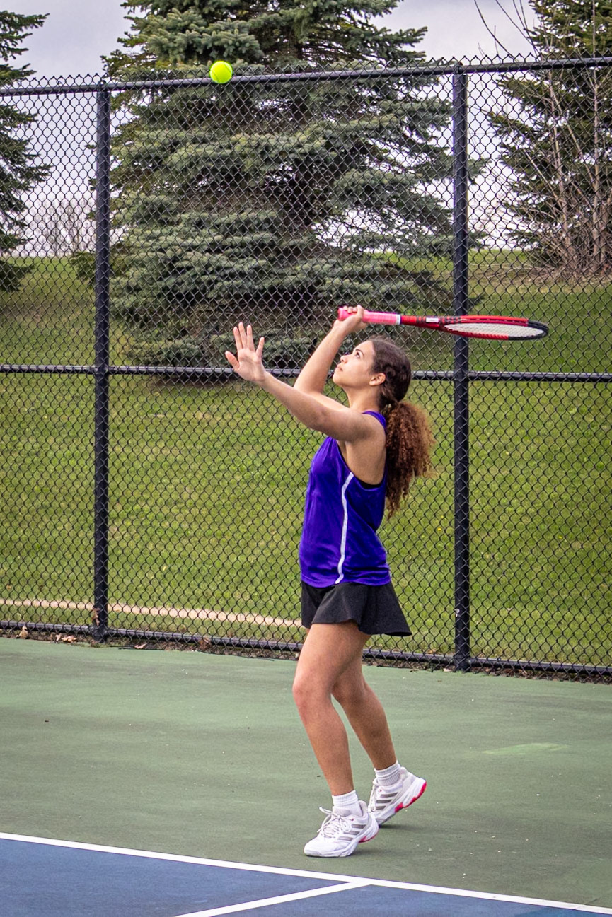 Payton Walker steps up to the line, eyes locked in as she goes in for a strong, focused serve to start the point. (Photo by Hailey Thayer)