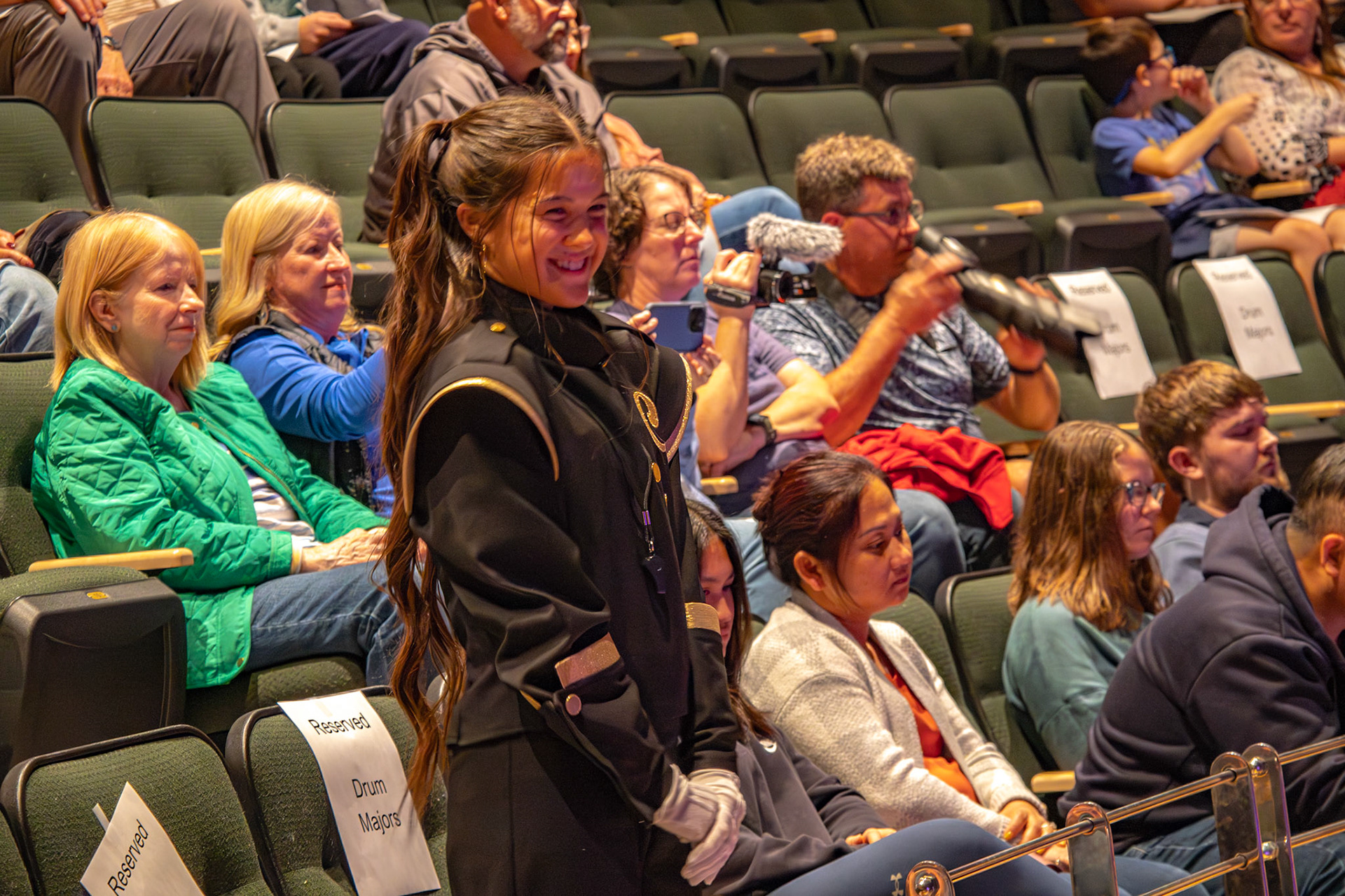 Senior Audrey Duong finishes conducting from the stands and lets out a big smile as her last fall concert comes to a end. (Photo by Jaren King)
