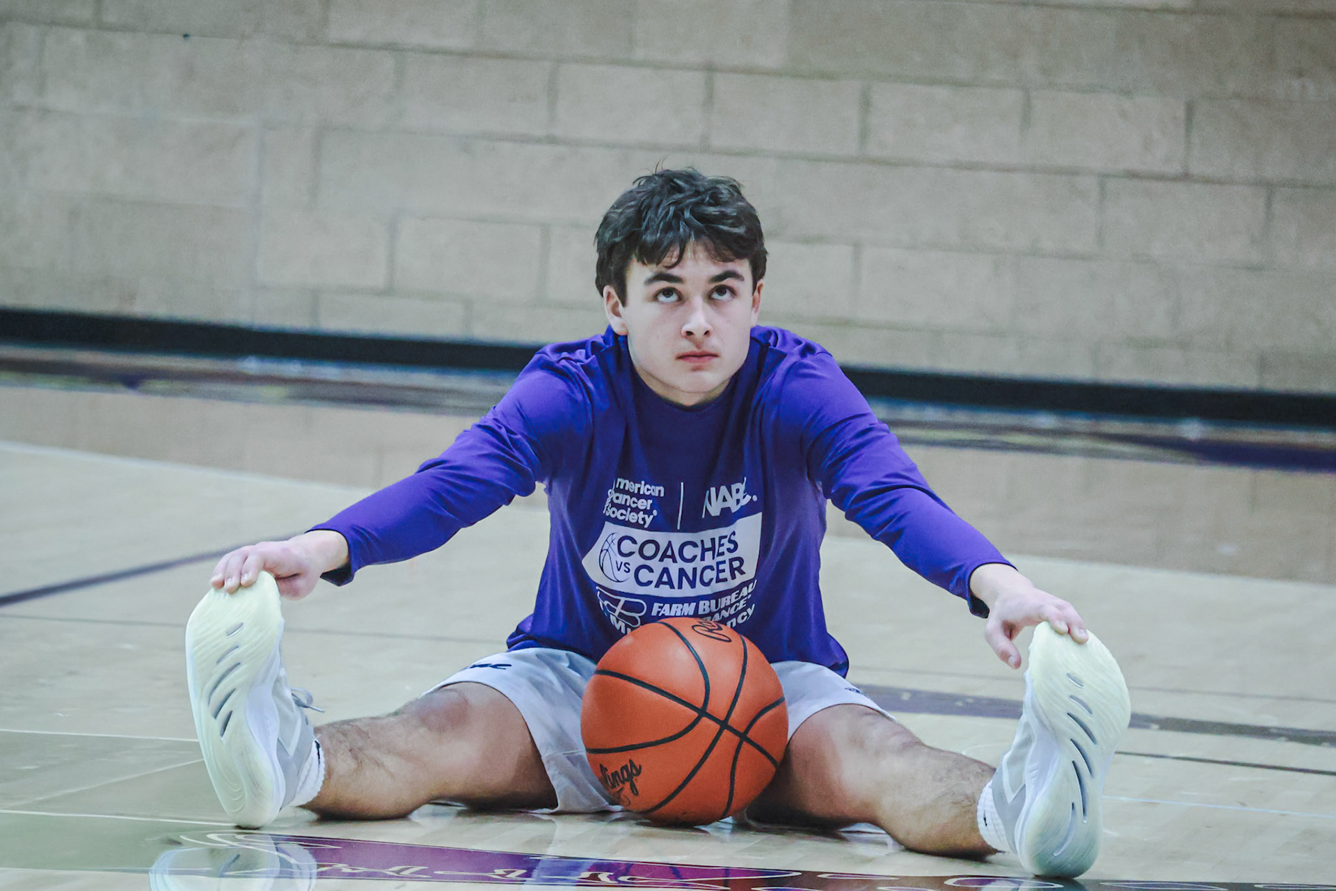 Conner Bloemers streches during warmups. (Photo by Aaron Pyper)