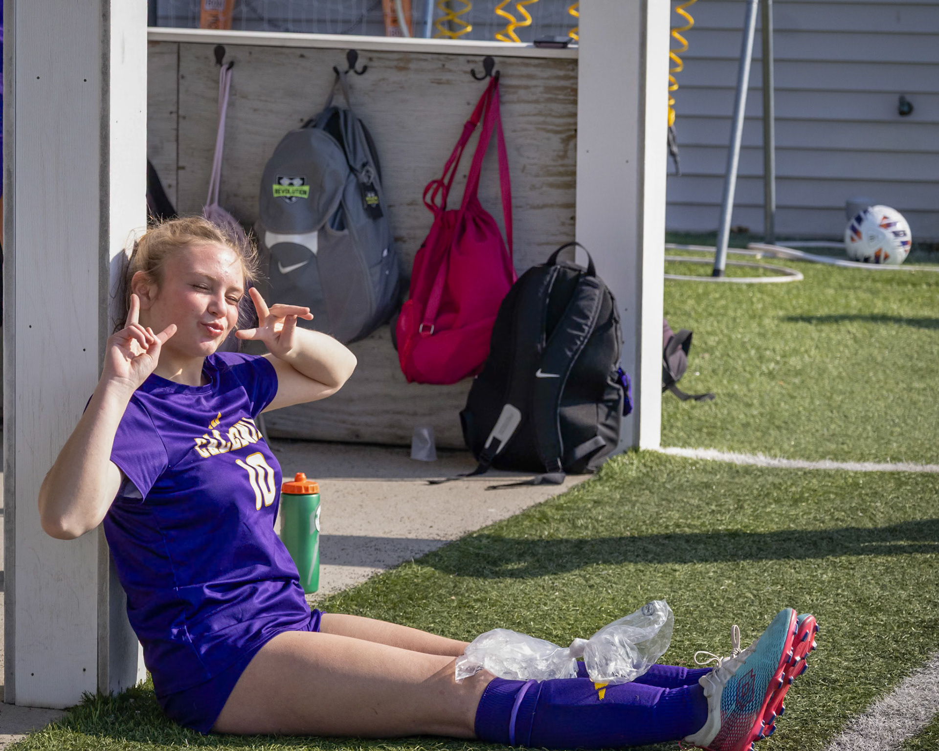 Maddie Blaser lies on the ground icing her knee after an injury during the game. (Photo by Ella-Grace Wickens)