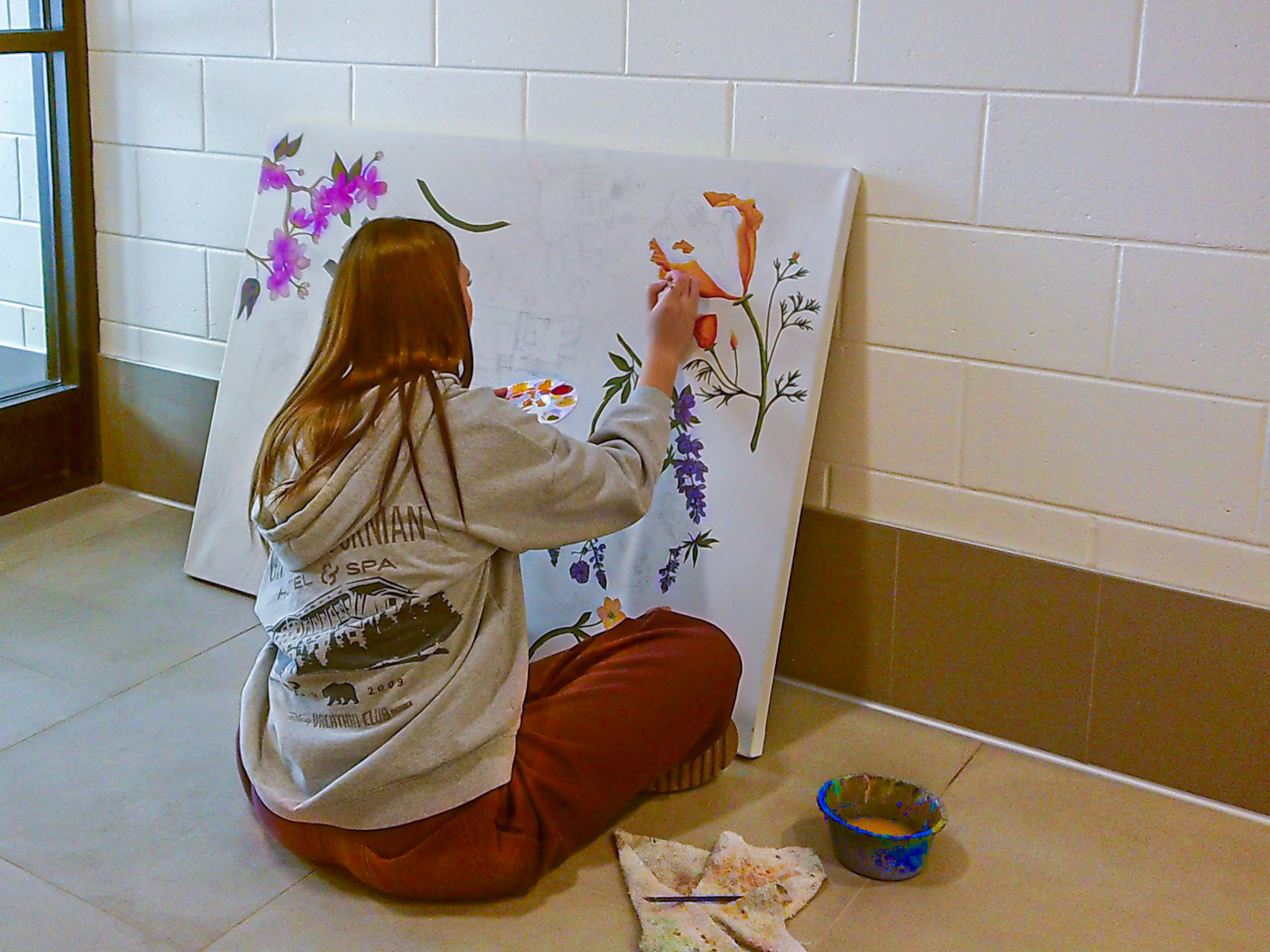 Kyla Charles dives into her AP Art project, brush in hand as she starts her ambitious painting of all the places she's lived. (Photo by Ava LaBine)