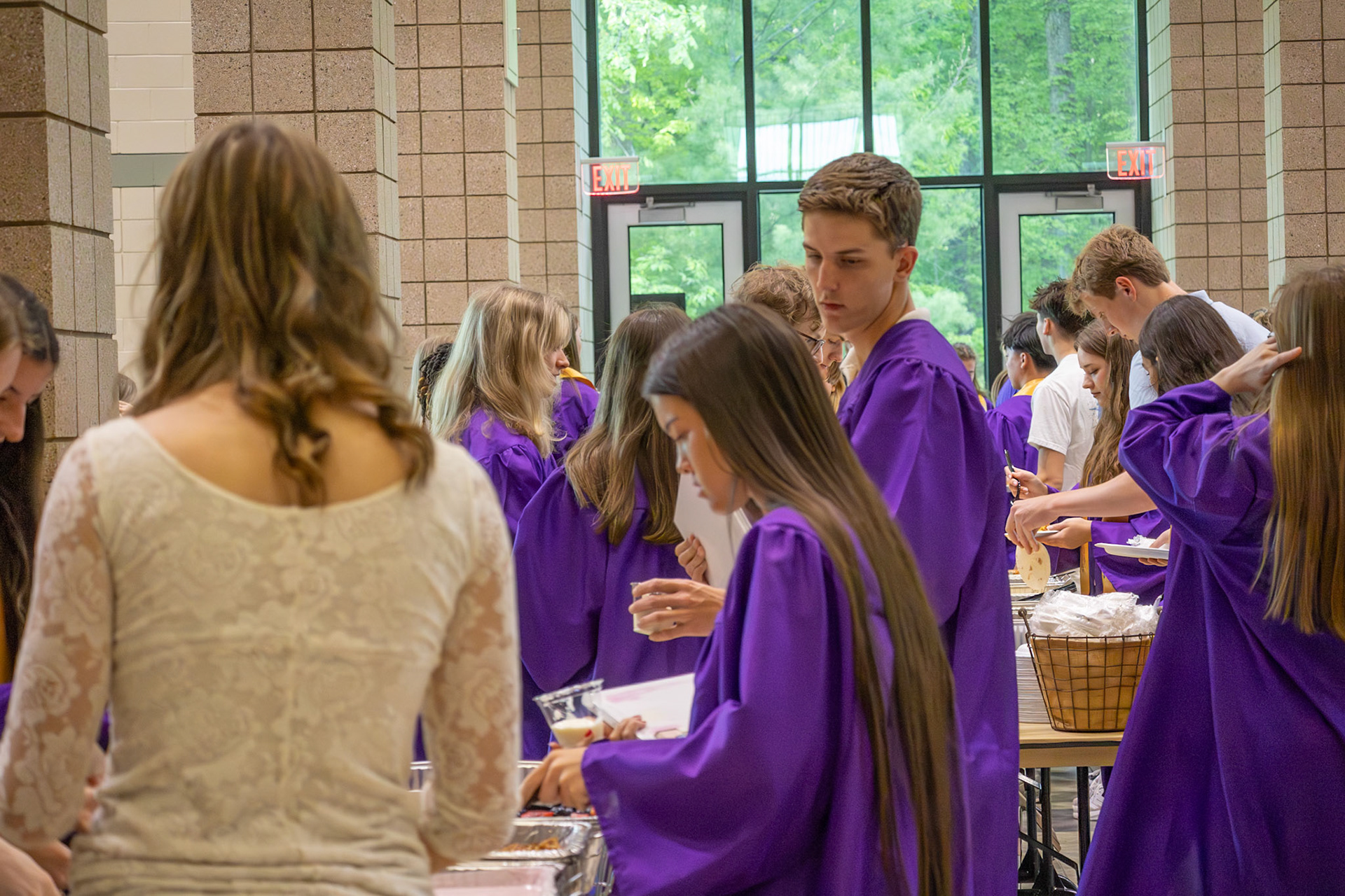 Seniors mingle in their gowns while enjoying delicious food at senior breakfast. (Photo by Emma Garza)