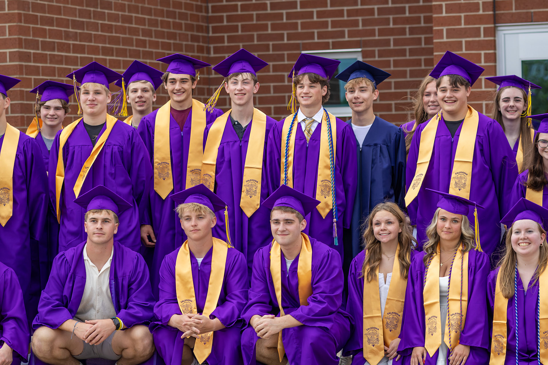 Senior class of 2026 smiles as all the parents take photos of them standing outside their old elementary school, Paris Ridge. (Photo by Emma Garza)