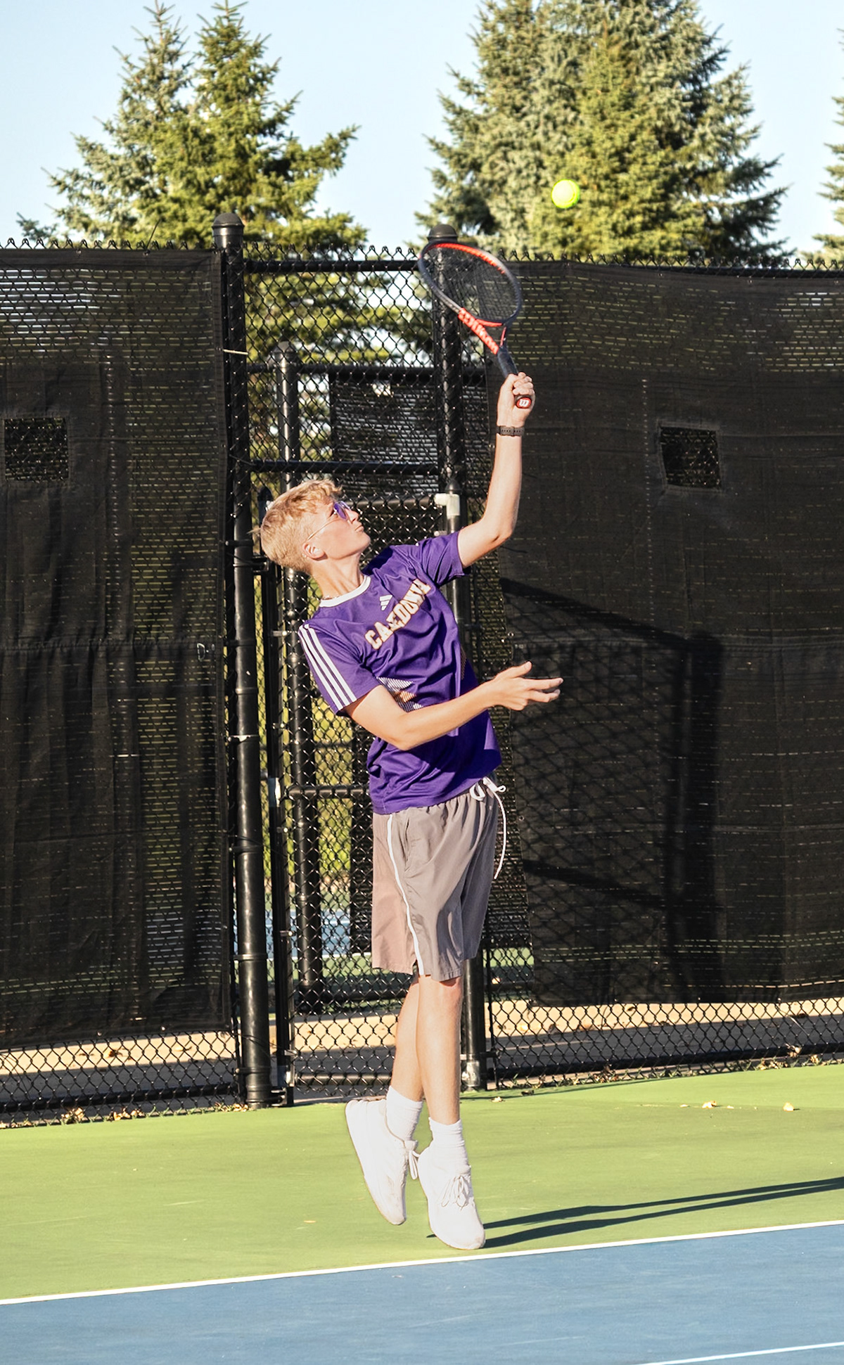 HIGH HIT  Peter Dykhouse rises onto his toes, ready to deliver the perfect serve. (Photo by Justin Harper)