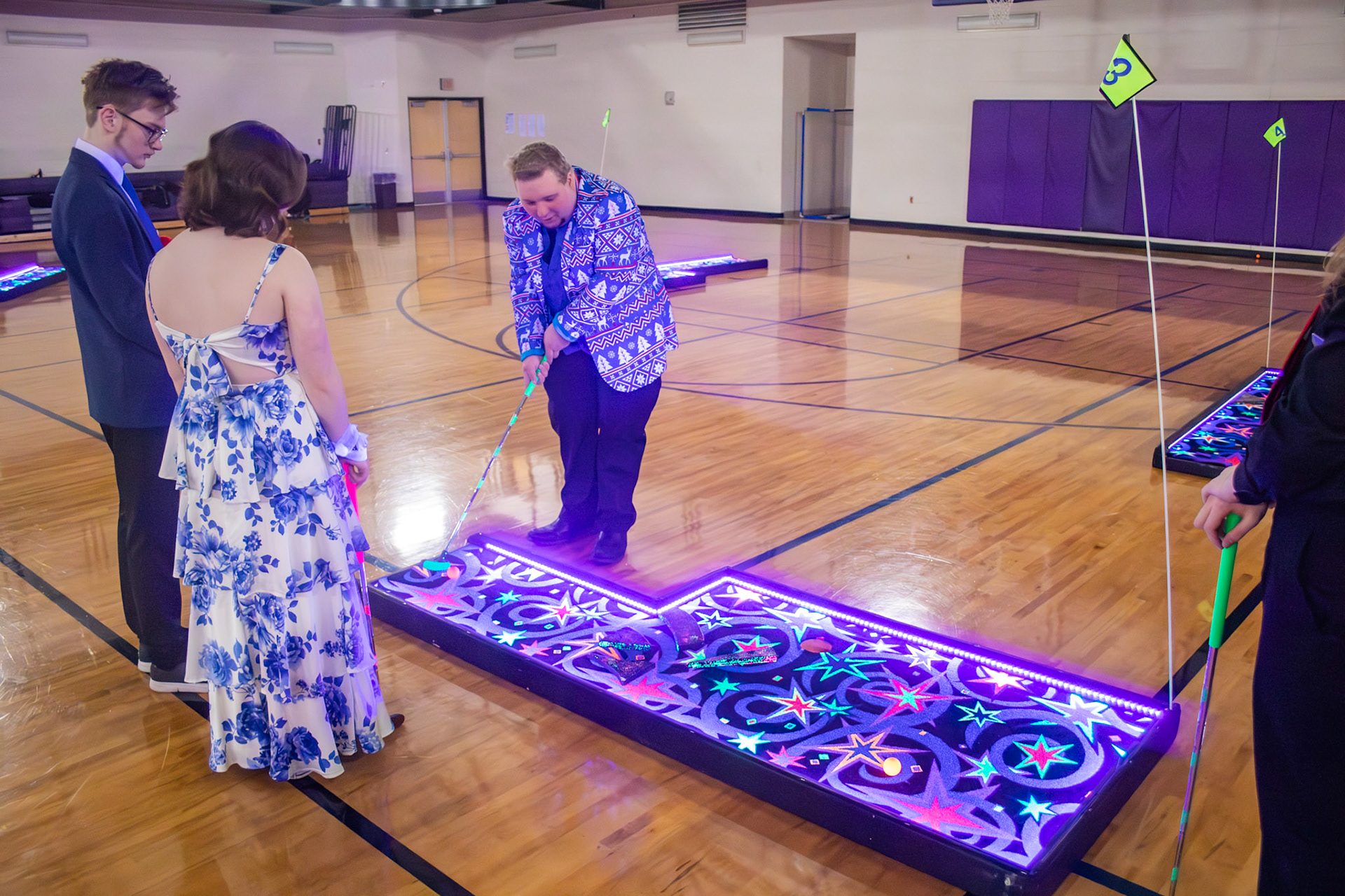 Alister Brew, with his friends, prepares for a putt at the 2026 Winterfest Dance. (Photo by Lucas Swartz)