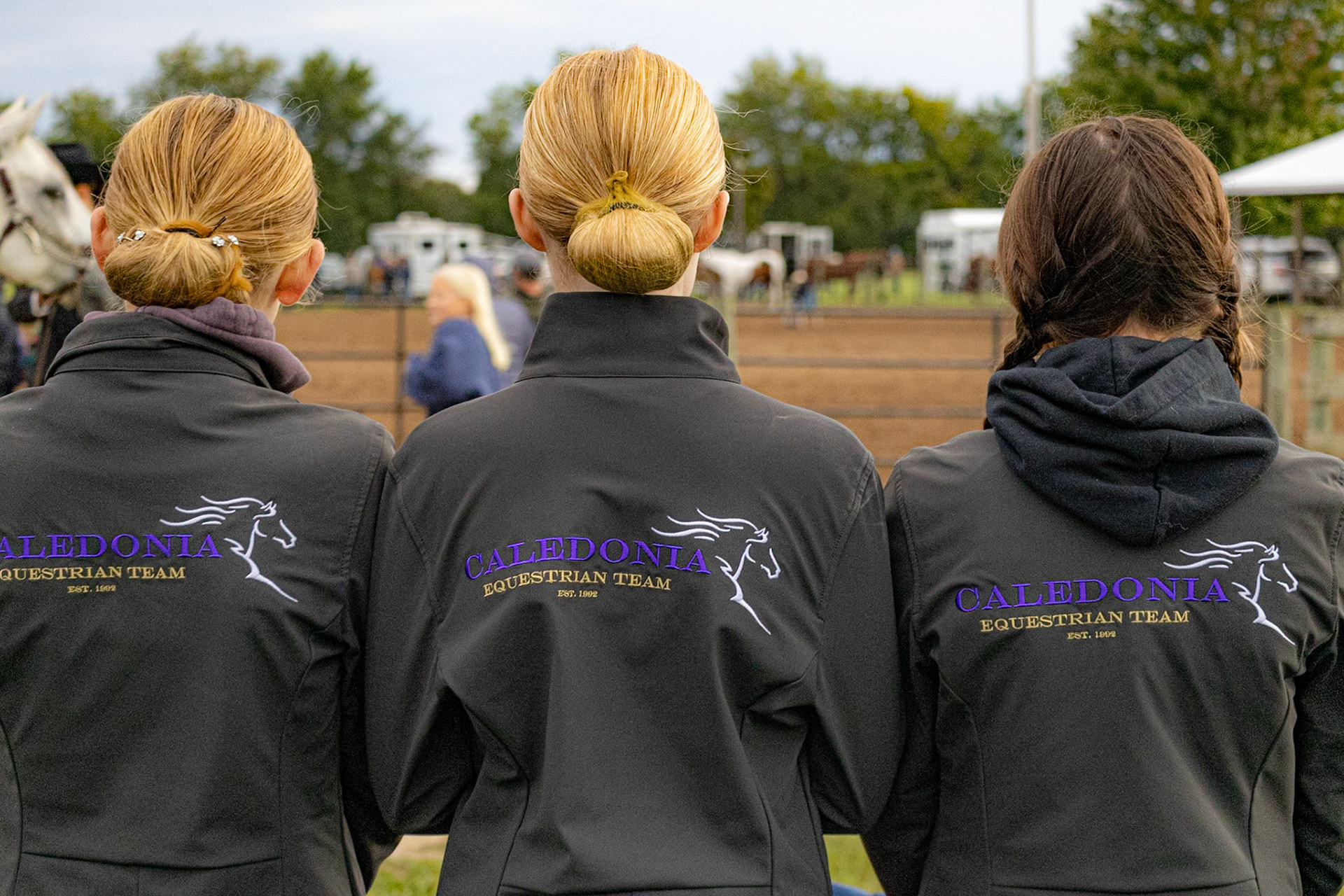 Three Equestrian Team members watch the competition unfold, sharing a quiet moment of connection. (Photo by Valentina Sosa)