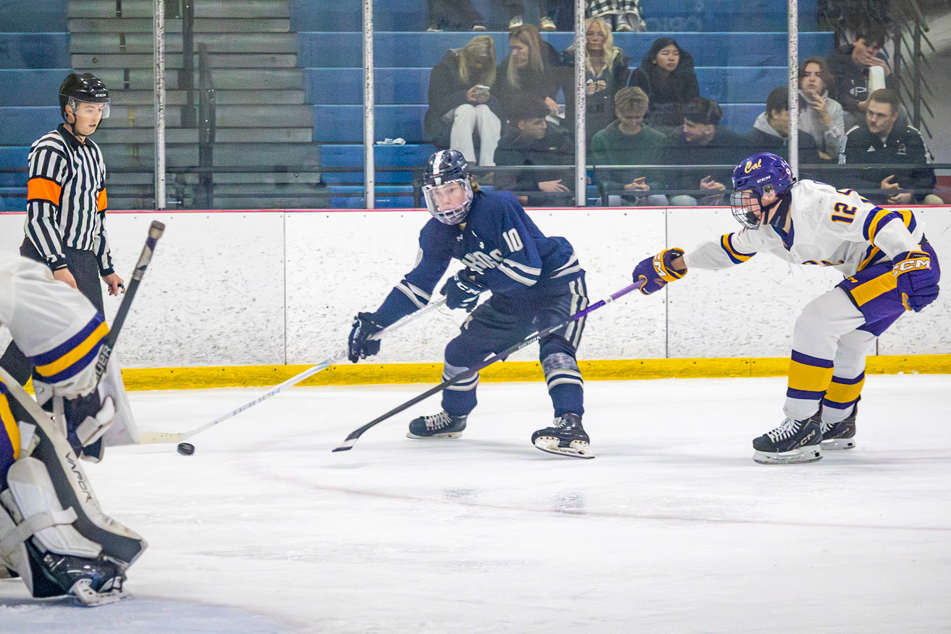 Swiping away at the defending team Camden Quigley reaches his stick out to block the other team from shooting. (Photo by Ella-Grace Wickens)