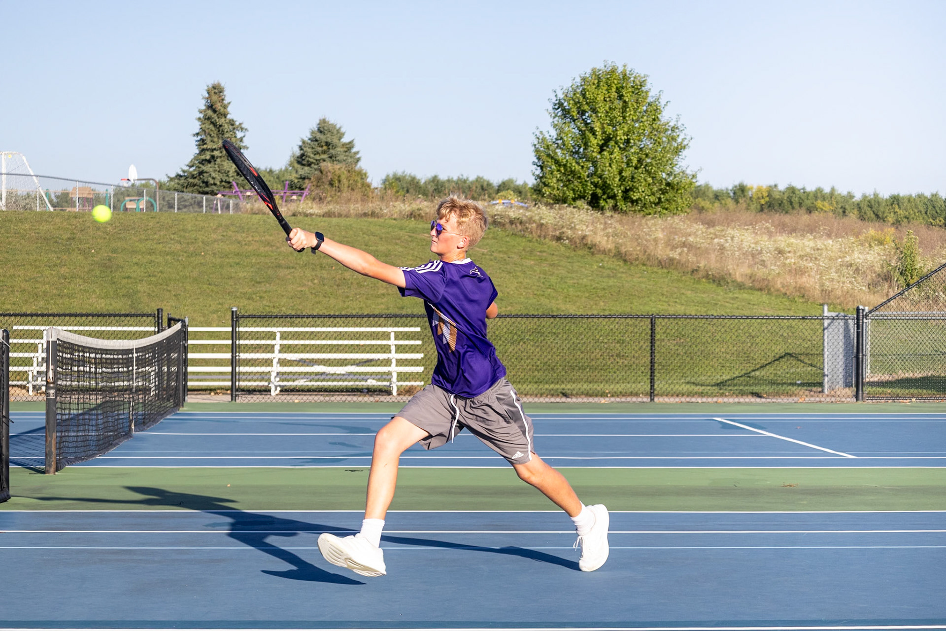 QUICK VOLLEY  Peter Dykhouse dashes forward, sending a fast volley that keeps Grand Haven on their toes. (Photo by Justin Harper)