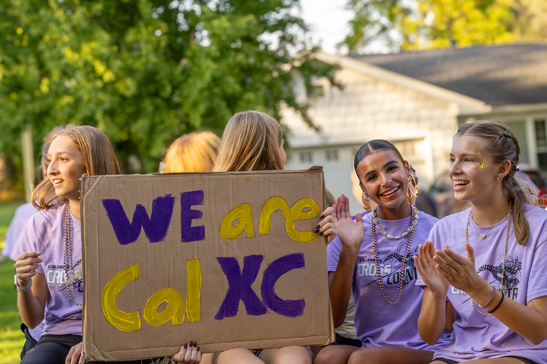 Sophomores Ainsley Fron, Tiona Sakala, and Elise Clarin keep the Homecoming excitement going from the cross country float. (Photo by Brianna Severson)