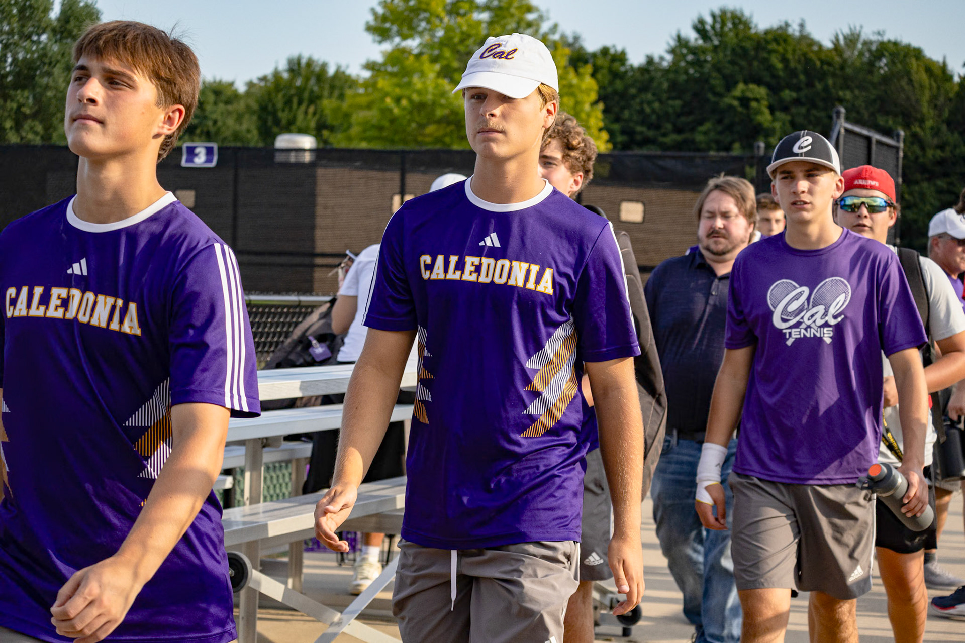 COURTSIDE CAMARADERIE After a hard-fought match, Quinn Stanley, Isaac Judd, and Russell Grandon exit the court. (Photo by Mackenzie Popma)