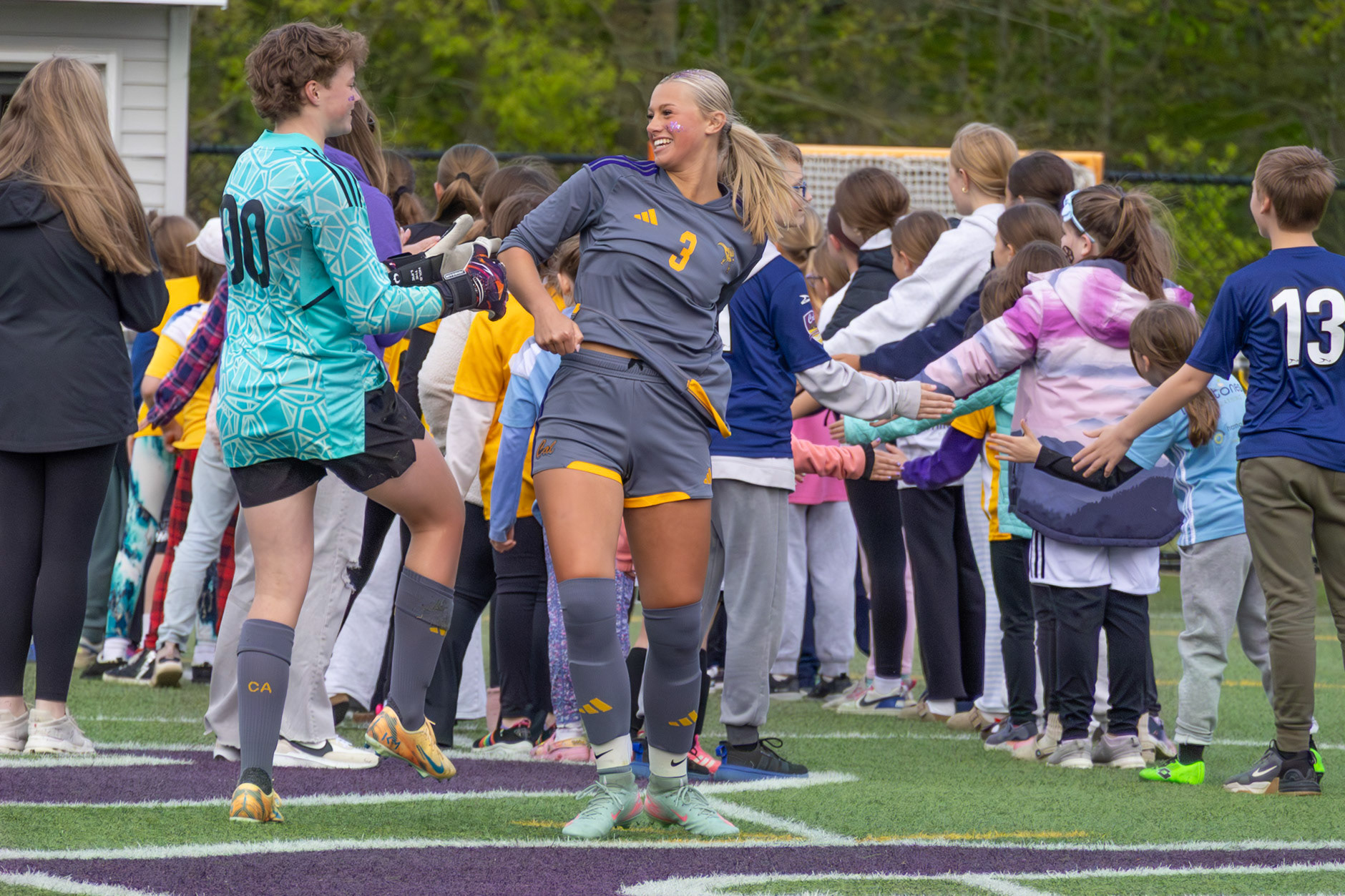 Lilli Ward hypes up Greeley Gingrich as she runs through the tunnel of kids during Youth Night. (Photo by Ava LaBine)