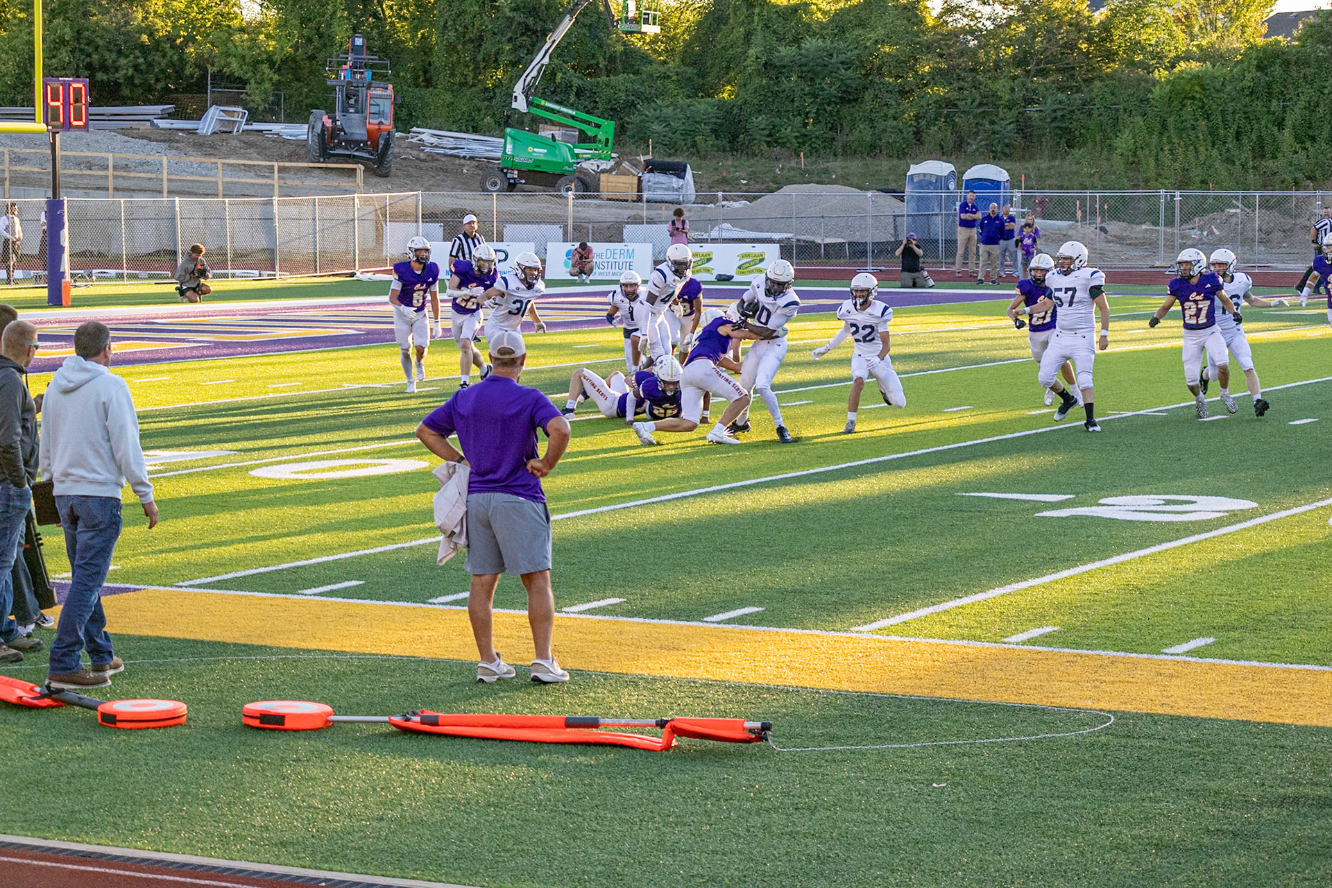 The football team warms up for the inaugural game in the new stadium, even as construction continues. (Photo by Elsha Bytwork)