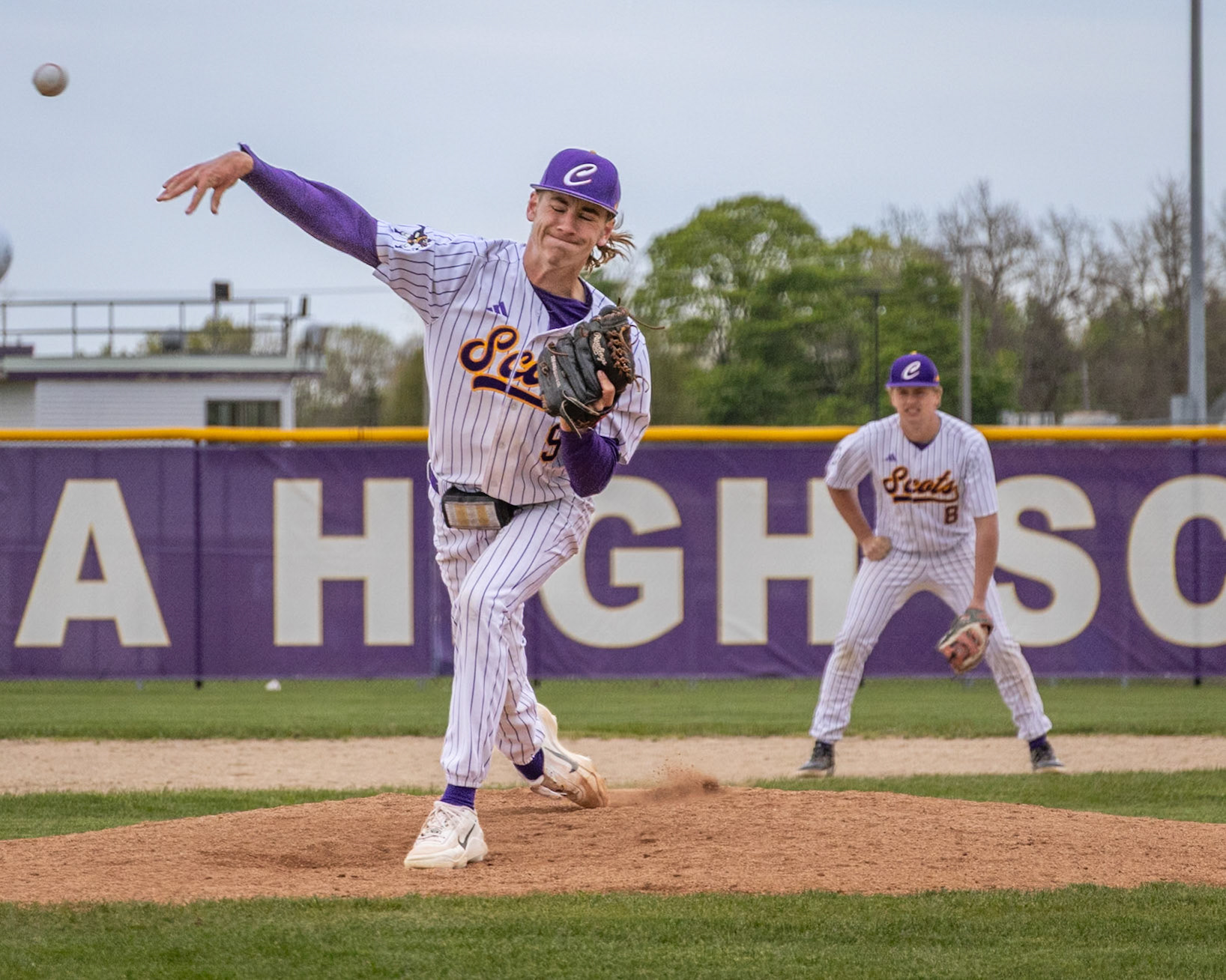 Senior Alex Spinney delivers a powerful pitch against Muskegon. (Photo by Vivian Hoffman)