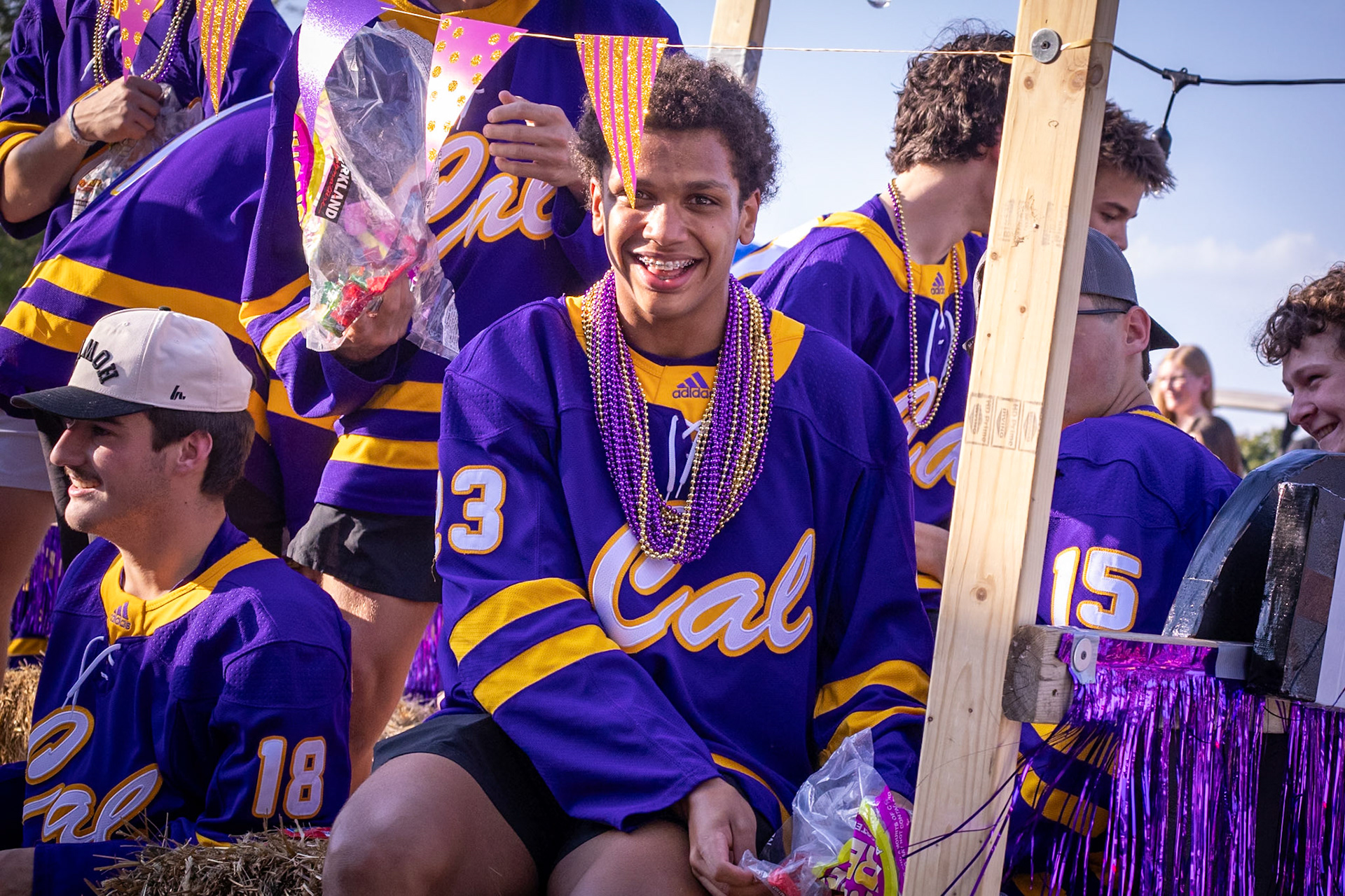 Junior Gabe Supuk smiles at the camera as he hands out candy from the hockey players’ float during the homecoming parade, spreading school spirit along the route. (Photo by Judah Dorband)
