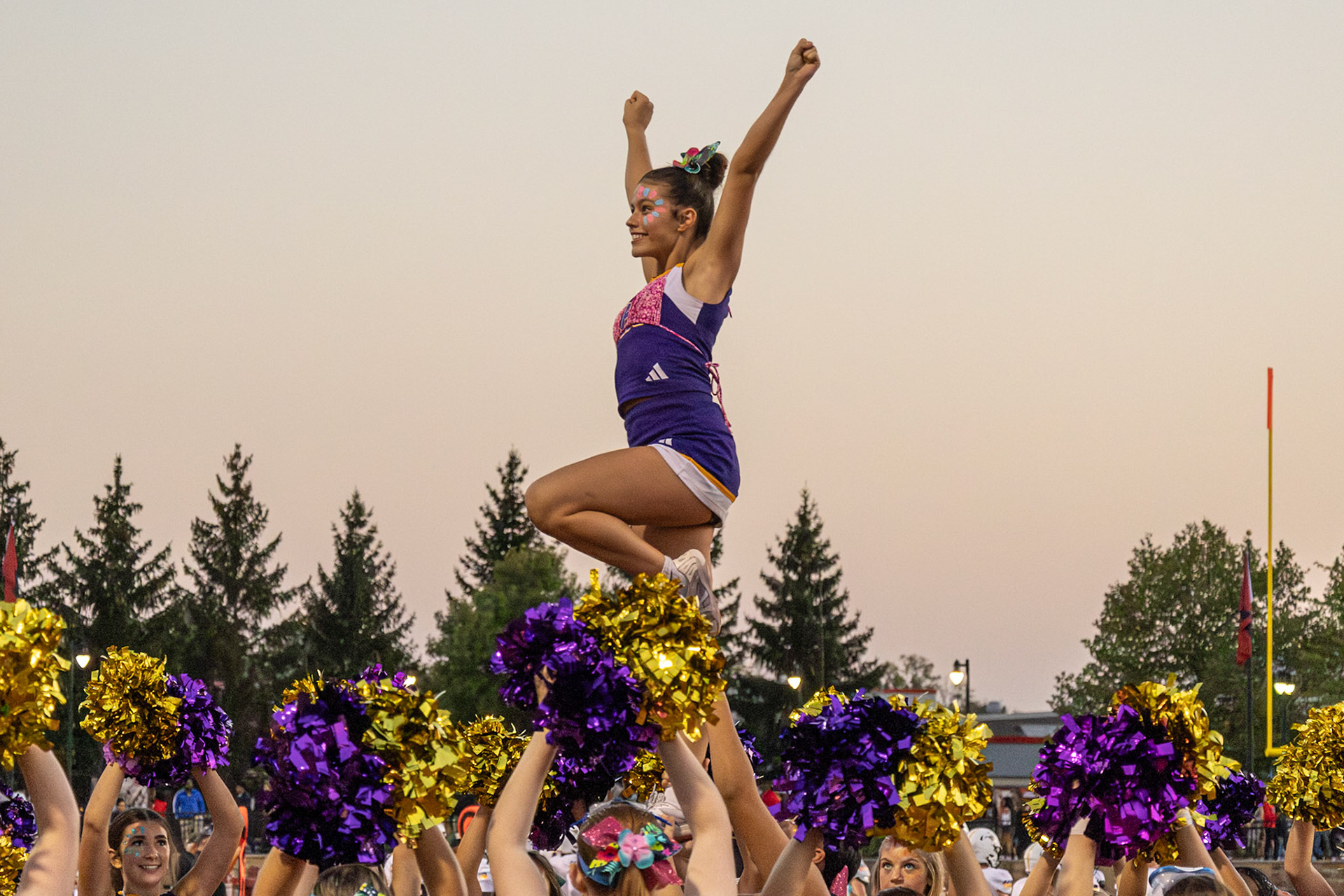 SOARING SPIRITS Adriana Twigg beams at the crowd as her fellow cheerleaders hold her up to the sky. (Photo by Avarey Lippert)