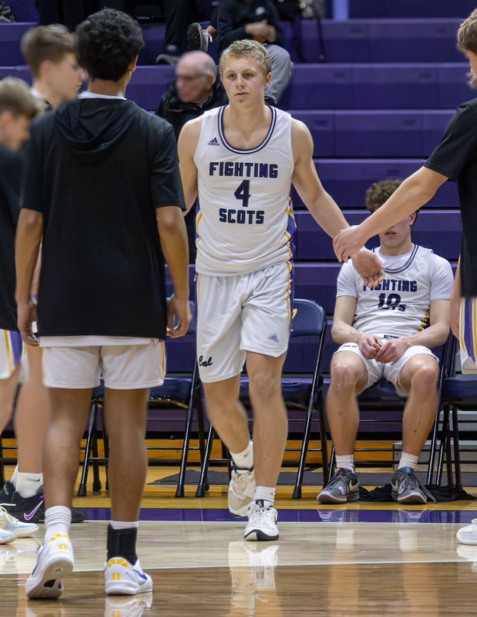 Logan Uyl's teammates dab him up as he enter the first period against Jenison. (Photo by Adi Malvankar)