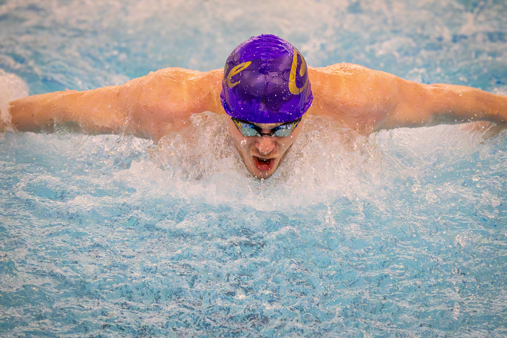While swimming as fast as he can to take first place, Nolan Fitzgerald demonstrates fantastic form during the 100-yard butterfly. (Photo by Hailey Thayer)