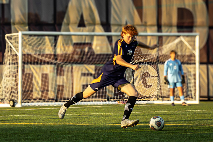 Caledonia earns a free kick, and Brecken Byrd steps up, sending a long pass across the field to Quentin Raffler before returning quickly to defense, ready to stop the opponents. (Photo by Clayton Palmer)