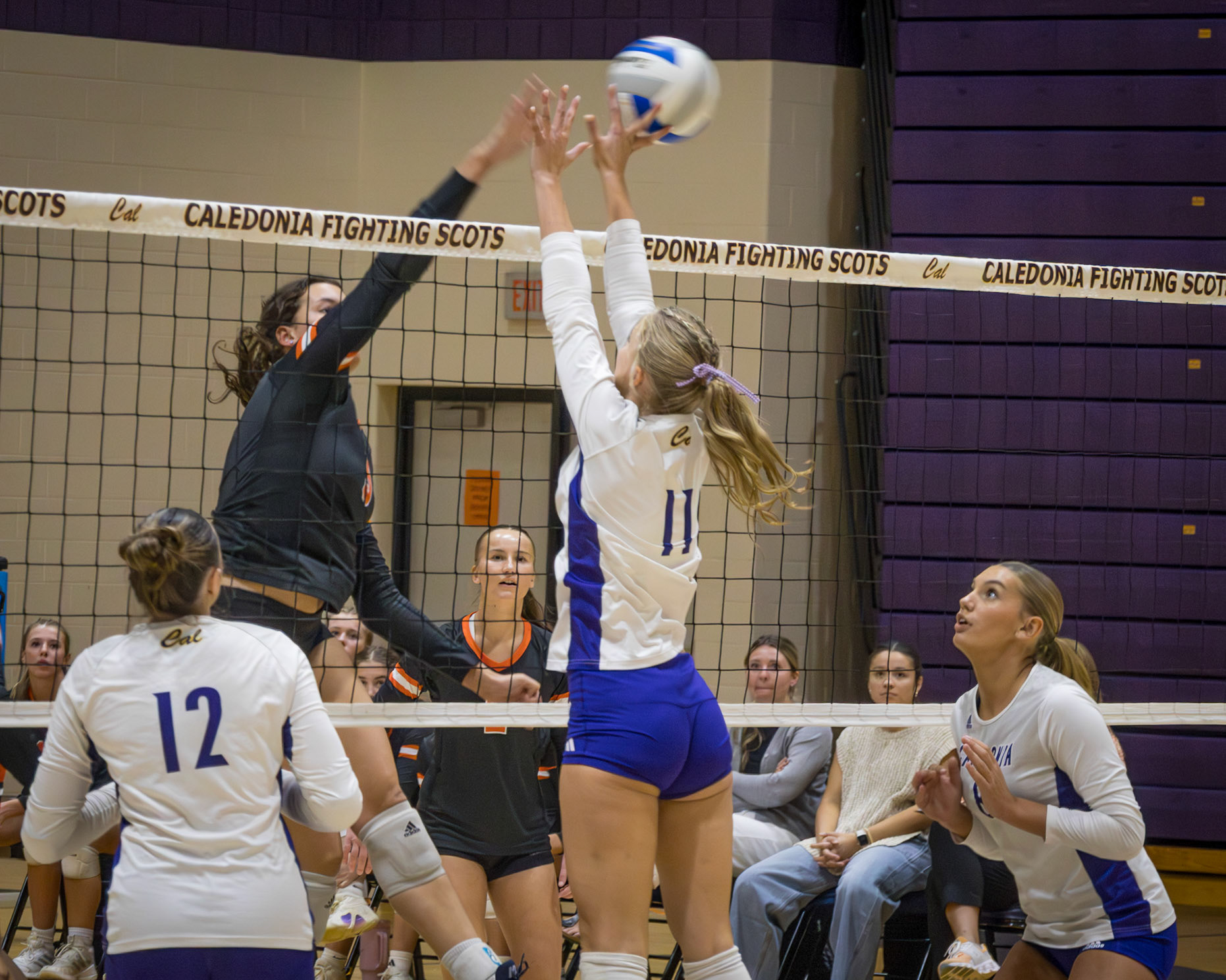 Senior Maggie Loomis gets up to block and tip's the hit from the Byron Center Bulldogs.  (Photo By Kortney Muller)