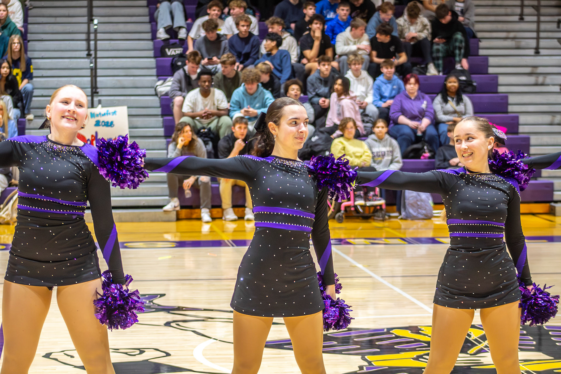Dynamic dance team trio sharing a focused glance mid-performance, perfectly in sync (Photo by Mya VanderZwaag)