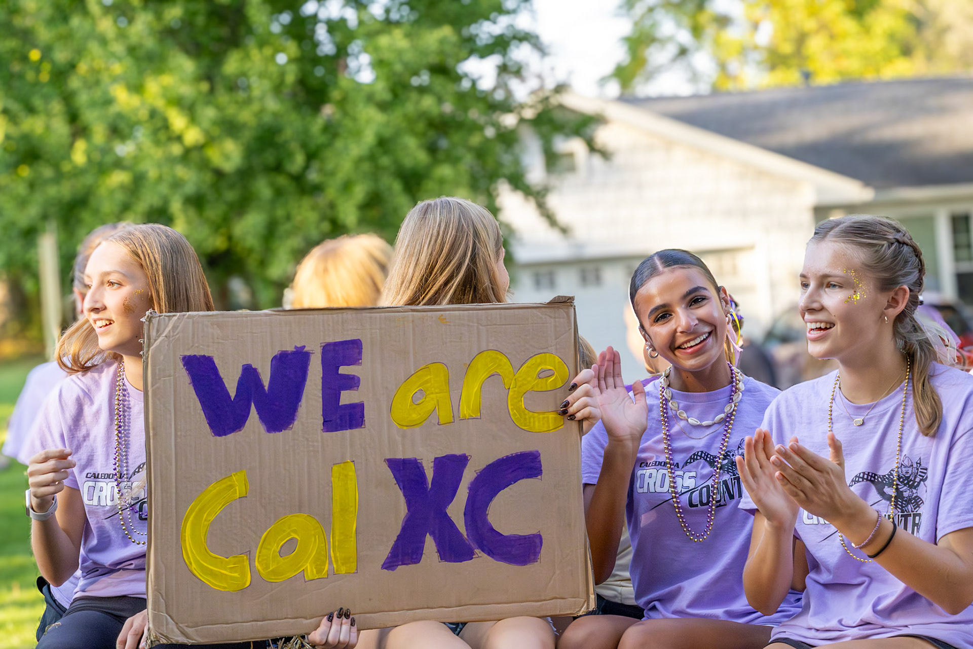 Sophomores Ainsley Fron, Tiona Sakala, and Elise Clarin keep the homecoming excitement high from the cross country float. (Photo by Brianna Severon)