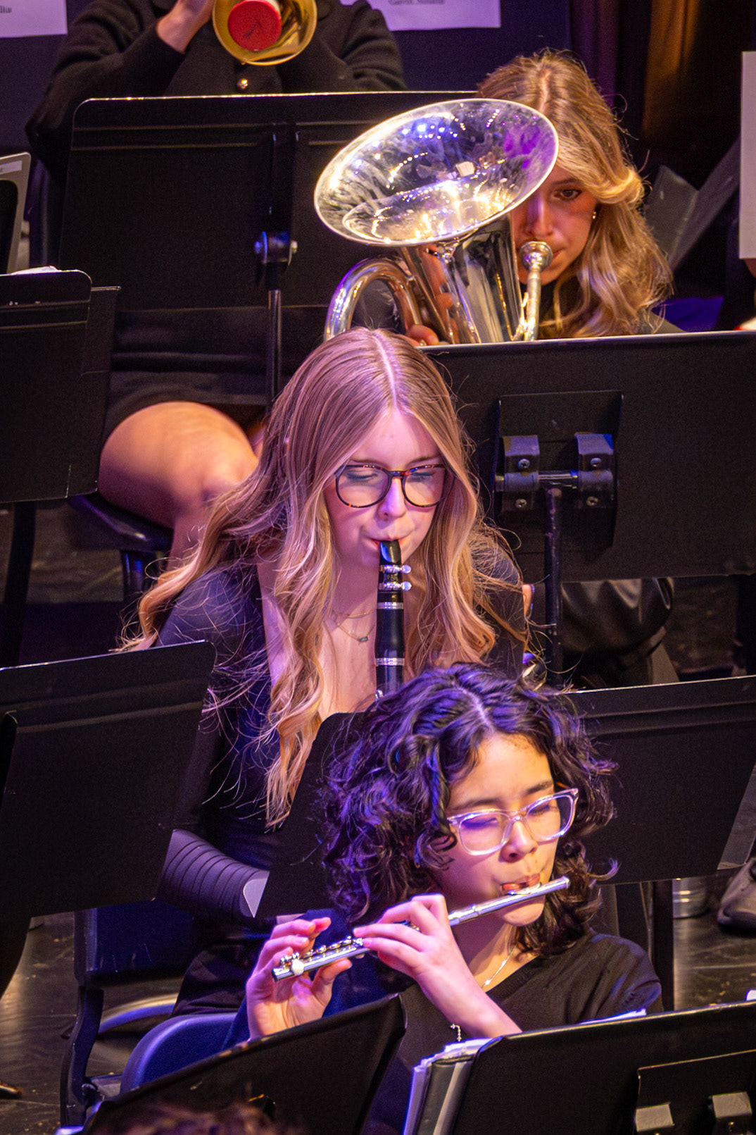 Junior Riley Kalacanic plays the clarinet while carefully watching her music, staying focused on the correct measure to keep her part aligned with the rest of the ensemble. (Photo by Mackenzie Popma)