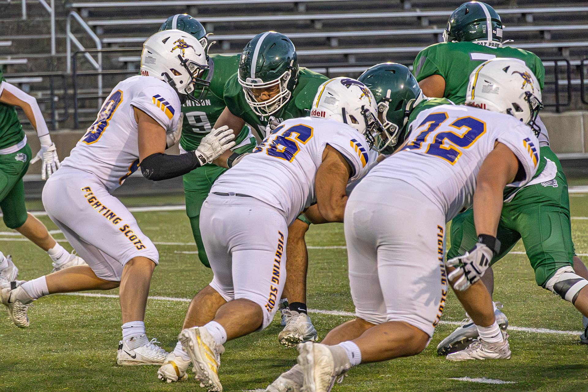 Defensive linemen Blake Whitlock, Izik Perez-Greene, and Elliot DeVries push through the Jenison offensive line, aiming to sack the quarterback. (Photo by Ella-Grace Wickens)
