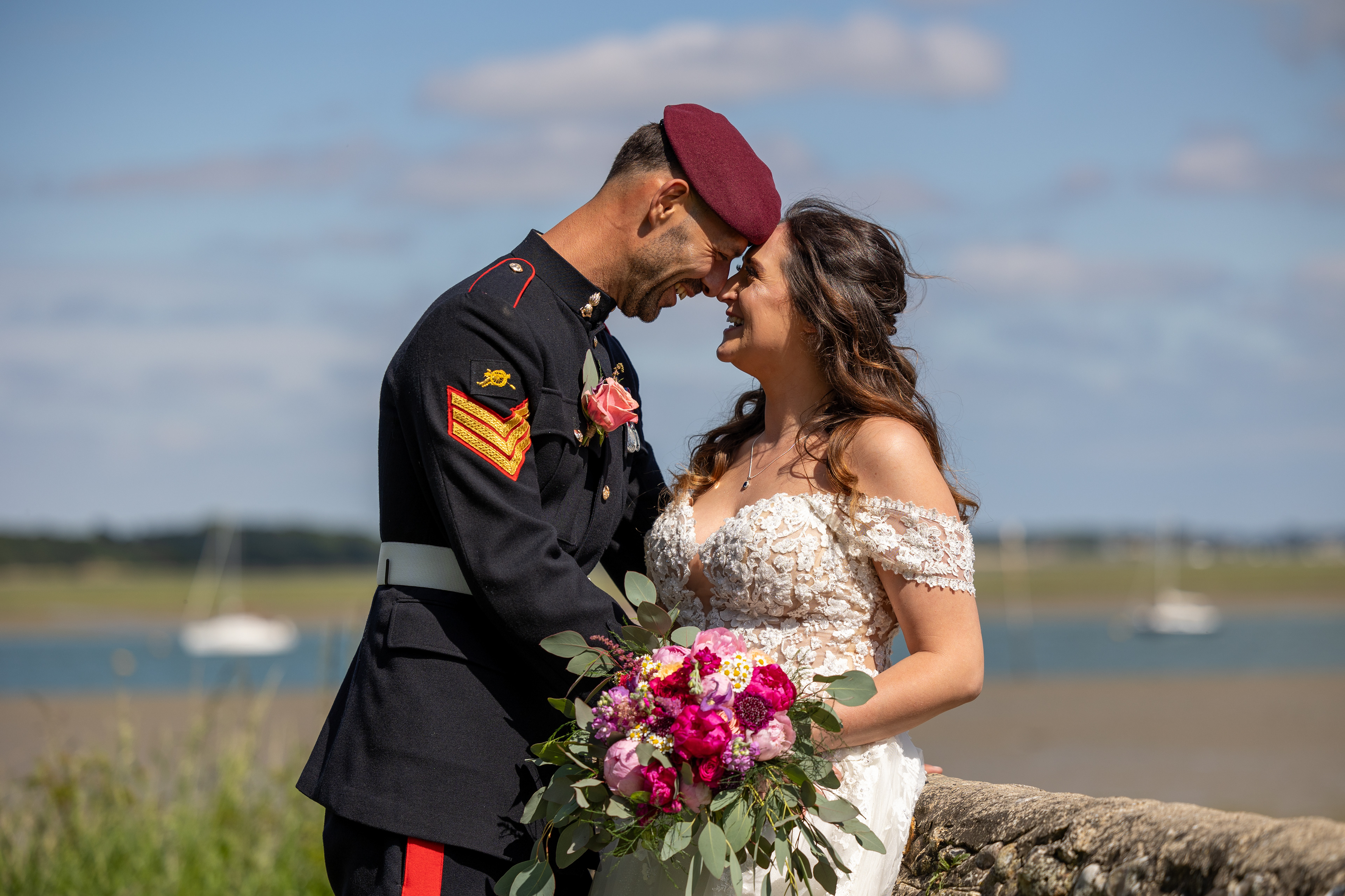 Newlyweds touching noses following their wedding ceremony, in cahoots on a harbor background