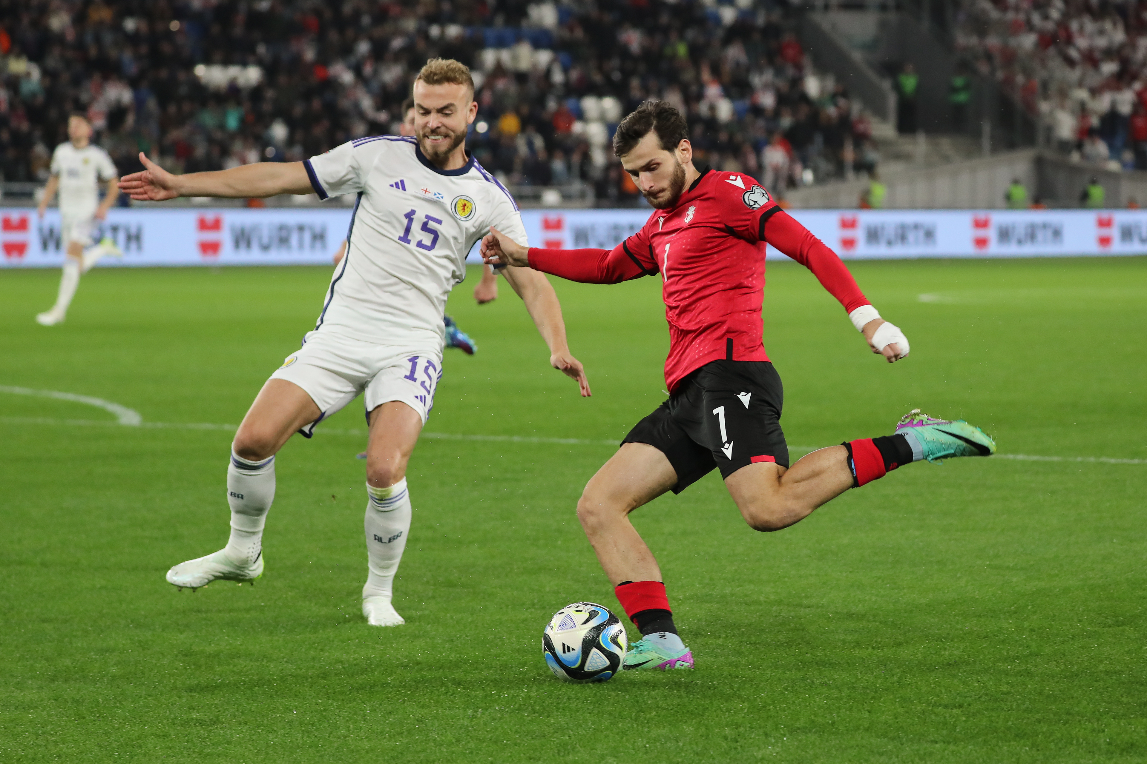 Khvicha Kvaratskhelia of Georgia shoots while challenged by Ryan Porteous of Scotland during a UEFA EURO qualifier in Tbilisi.