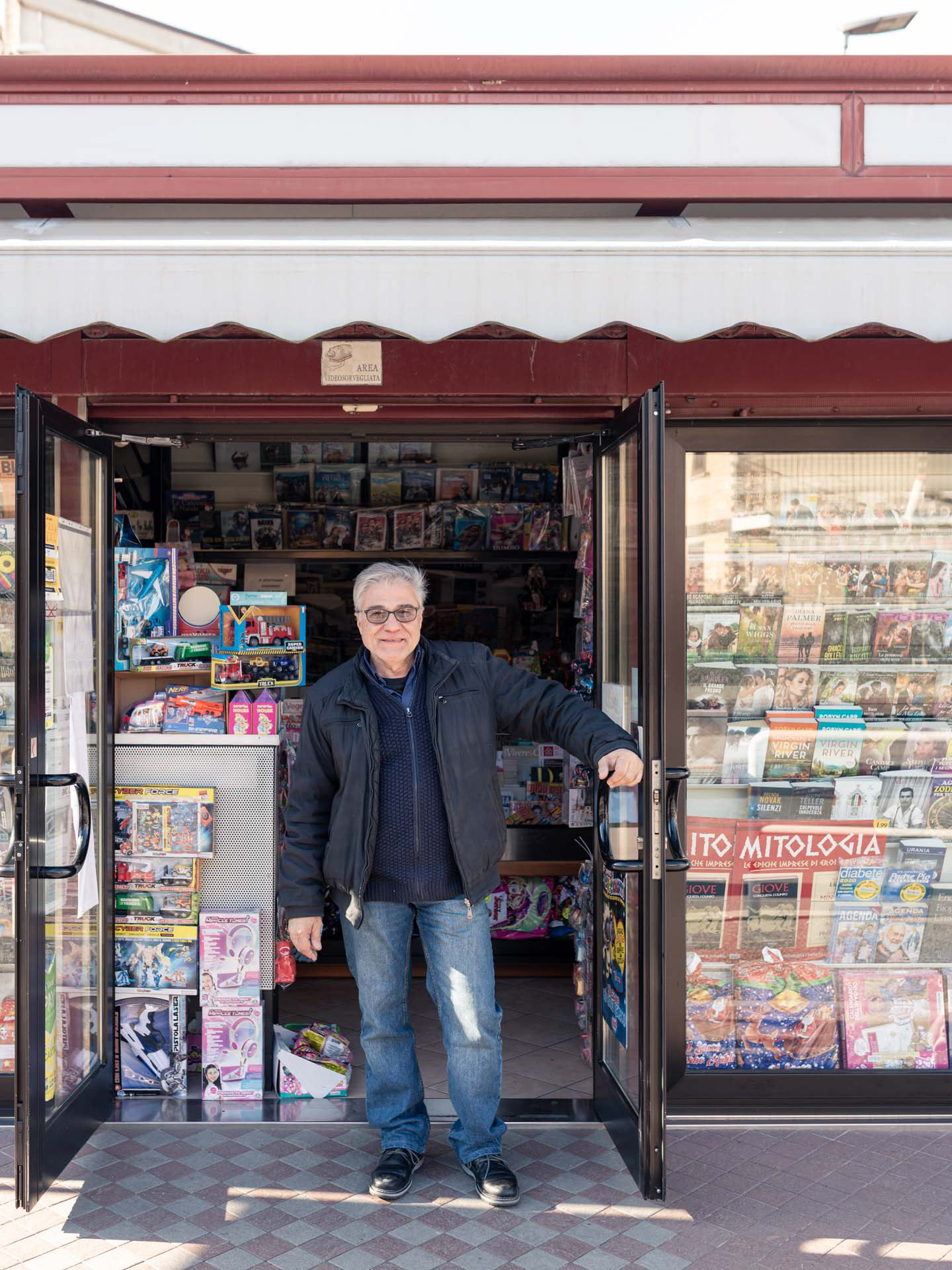 ritratto di edicolante davanti alla sua edicola