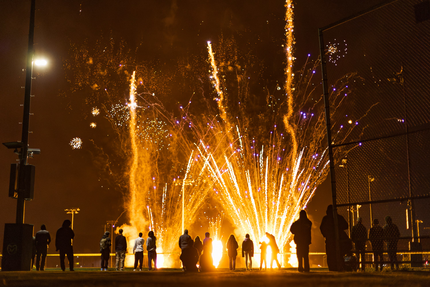 Colorado State University community members watch a fireworks show on the Intramural Fields during Friday Night Lights Oct. 13. Part of CSU's homecoming celebration, the event features performances from the marching band, color guard and cheerleaders, as well as speeches from sports coaches, a bonfire, fireworks and a DJ performance.