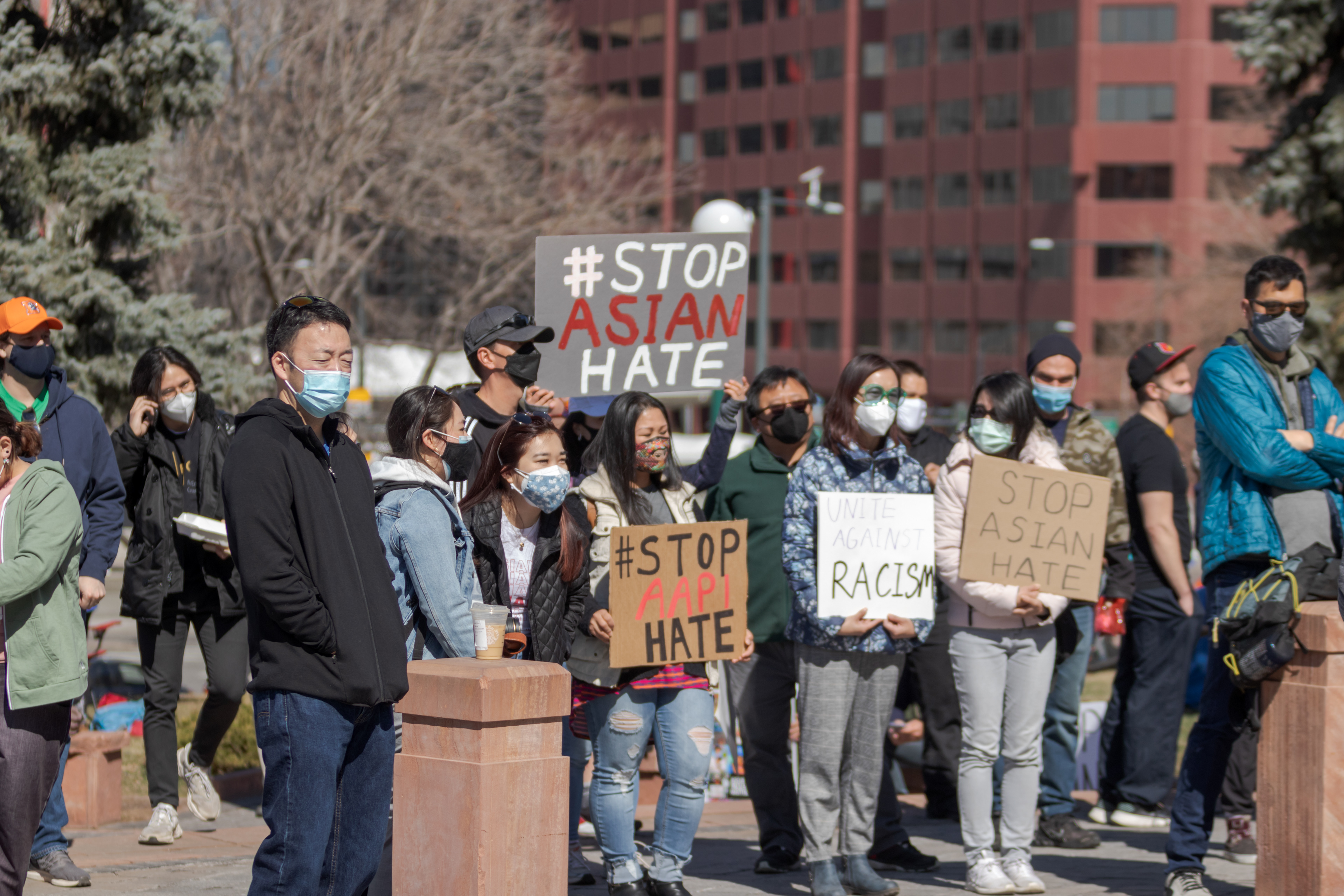 Protesters hold signs outside the Colorado State Capitol March 27. The protest featured speeches, poetry, and music from the Asian-American and Pacific Islander community.
