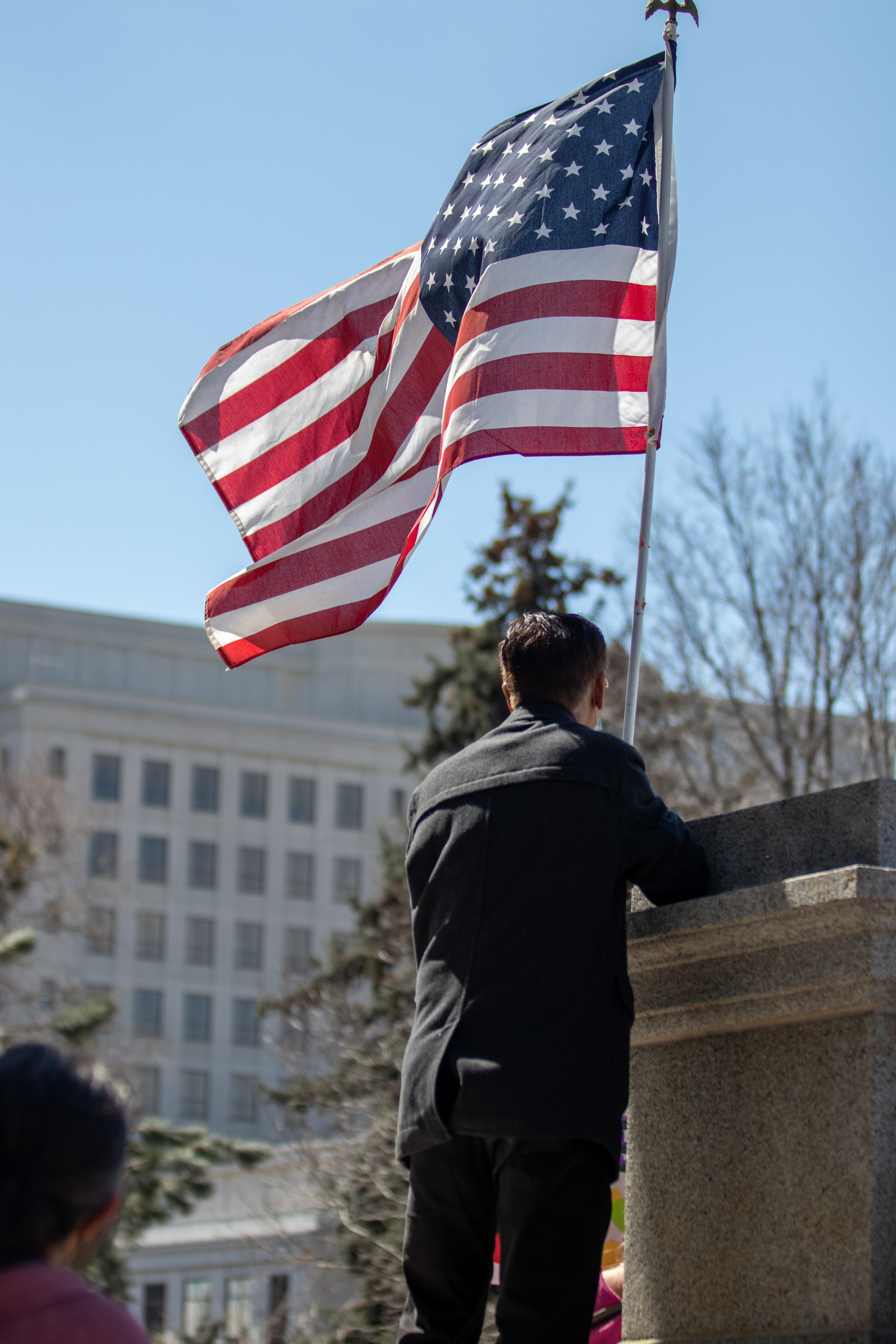 Benjamin Cheang holds a flag outside the Colorado State Capitol during a protest March 27. The protest featured speeches, poetry, and music from the Asian-American and Pacific Islander community.
