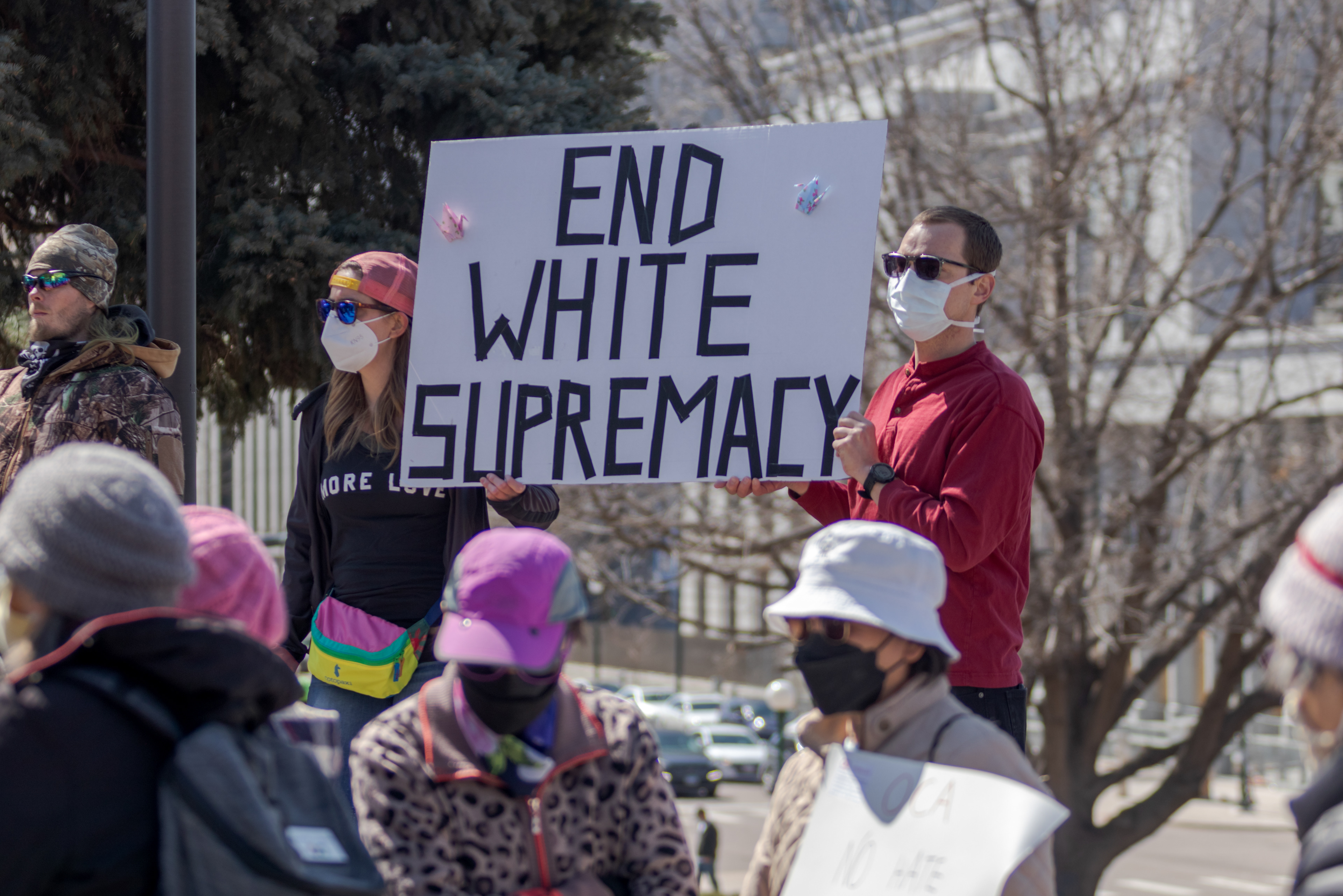 Julia Bryan and Johnston Robare hold a sign during a protest outside the Colorado State Capitol March 27. Bryan said she came to the protest to "show support for our Asian brothers and sisters and Pacific Islanders... and also send a message to our White brothers and sisters that we need to do our part, get educated, and listen".