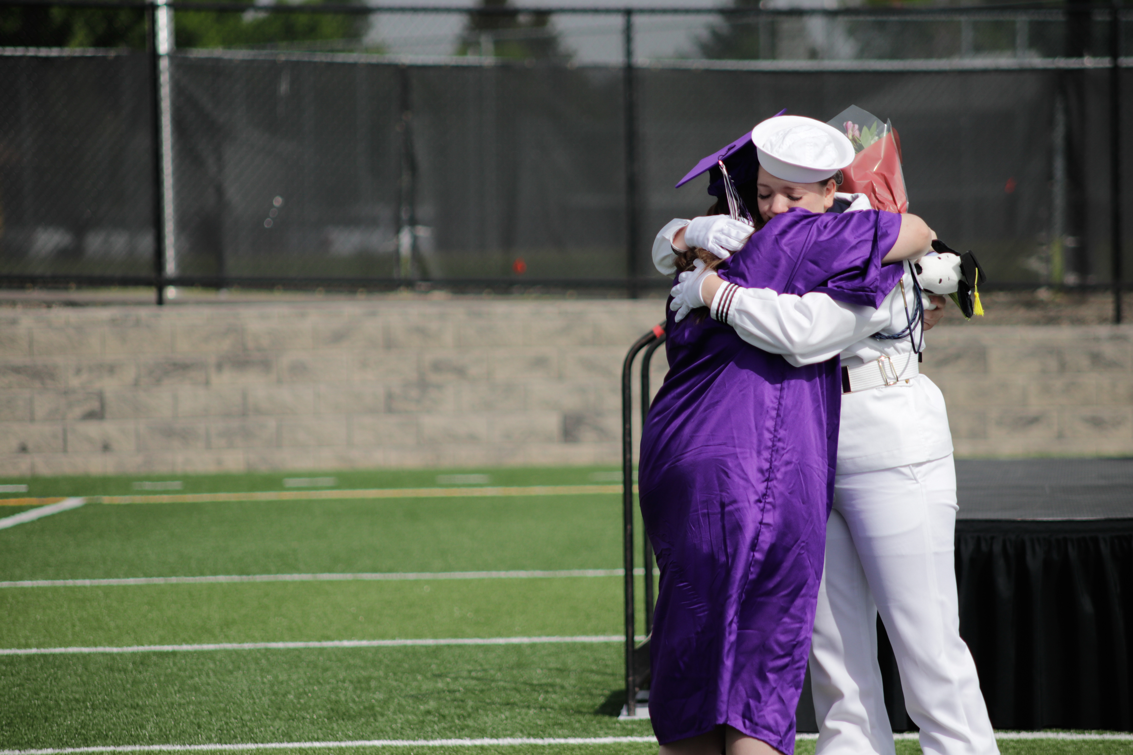 LOVELAND, CO - MAY 29, 2021: Mountain View graduate Julia Study hugs her twin Jessica Study during her graduation ceremony Saturday, May 29, 2021 at Patterson Field in Loveland. (Michael Marquardt/Loveland Reporter-Herald)