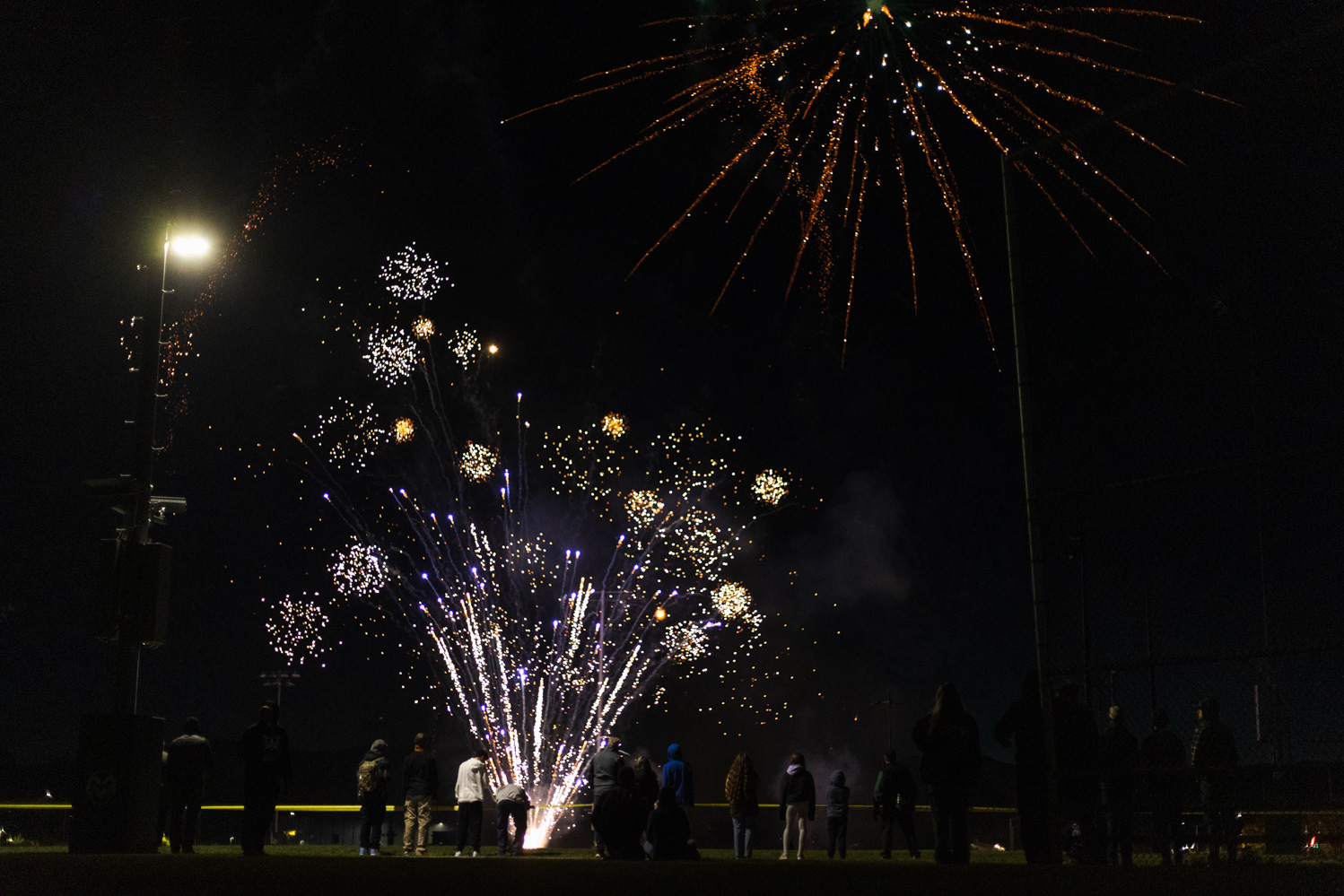 Colorado State University community members watch a fireworks show on the Intramural Fields during Friday Night Lights Oct. 13. Part of CSU's homecoming celebration, the event features performances from the marching band, color guard and cheerleaders, as well as speeches from sports coaches, a bonfire, fireworks and a DJ performance.