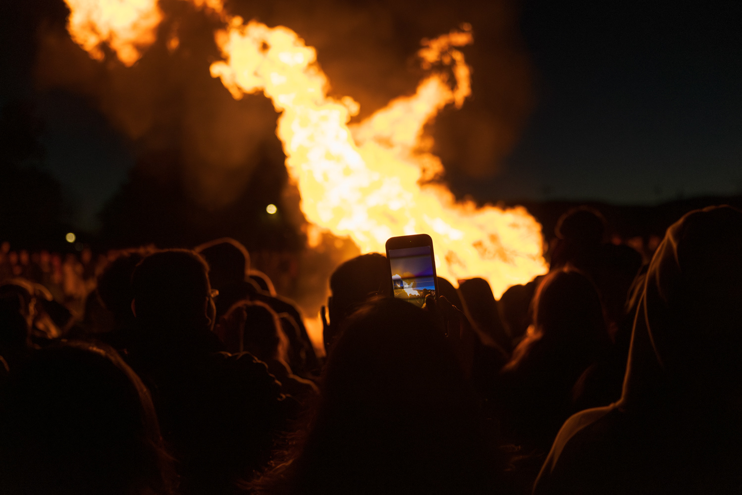 A Colorado State University community member photographs the bonfire at Friday Night Lights Oct. 13. Part of CSU's homecoming celebration, the event features performances from the marching band, color guard and cheerleaders, as well as speeches from sports coaches, a bonfire, fireworks and a DJ performance.