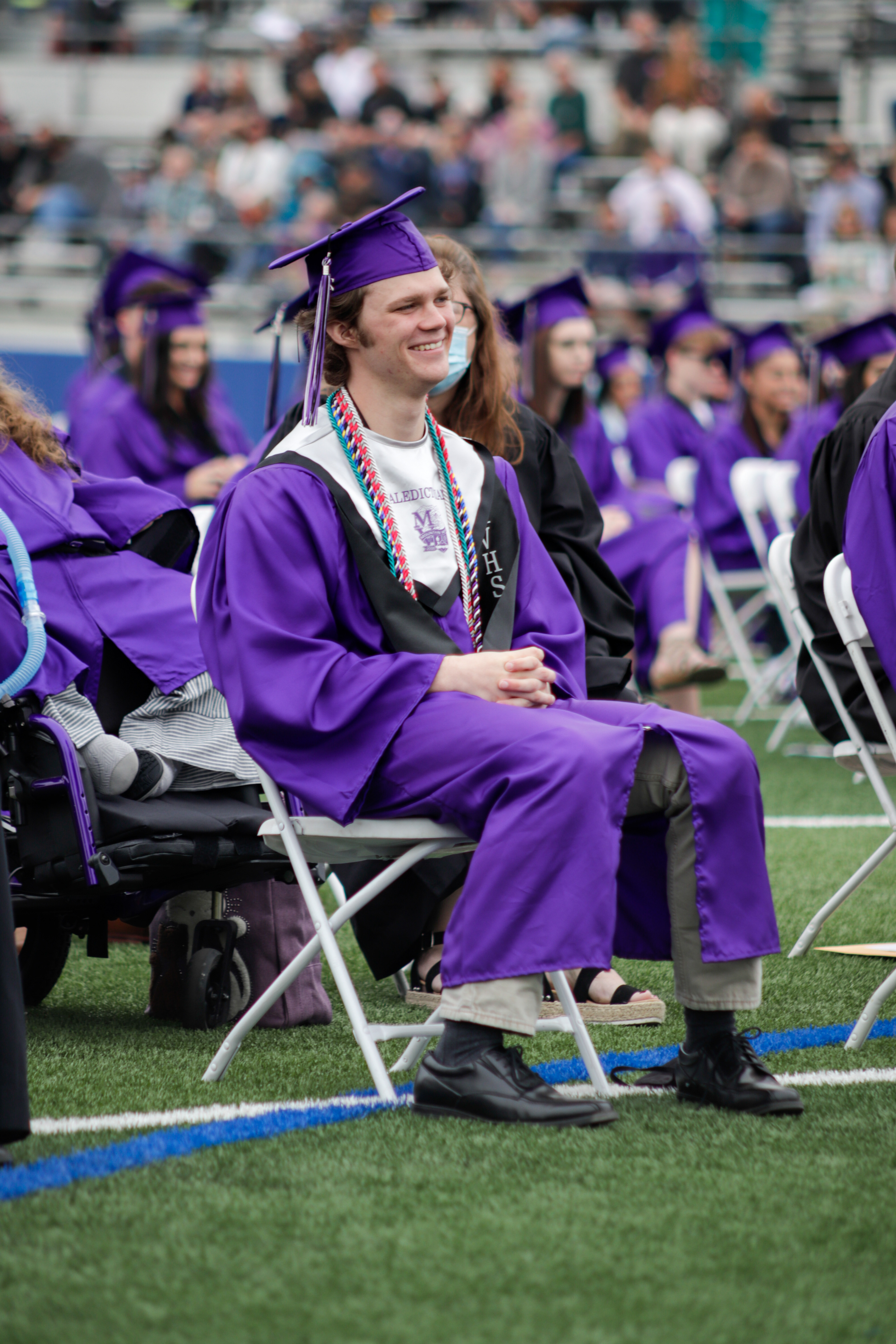 LOVELAND, CO - MAY 29, 2021: Mountain View Valedictorian Braden Bomgaars laughs at  Assistant Principal and Staff Speaker Nathan Gurrini's speech during the graduation ceremony Saturday, May 29, 2021 at Patterson Field in Loveland. (Michael Marquardt/Loveland Reporter-Herald)