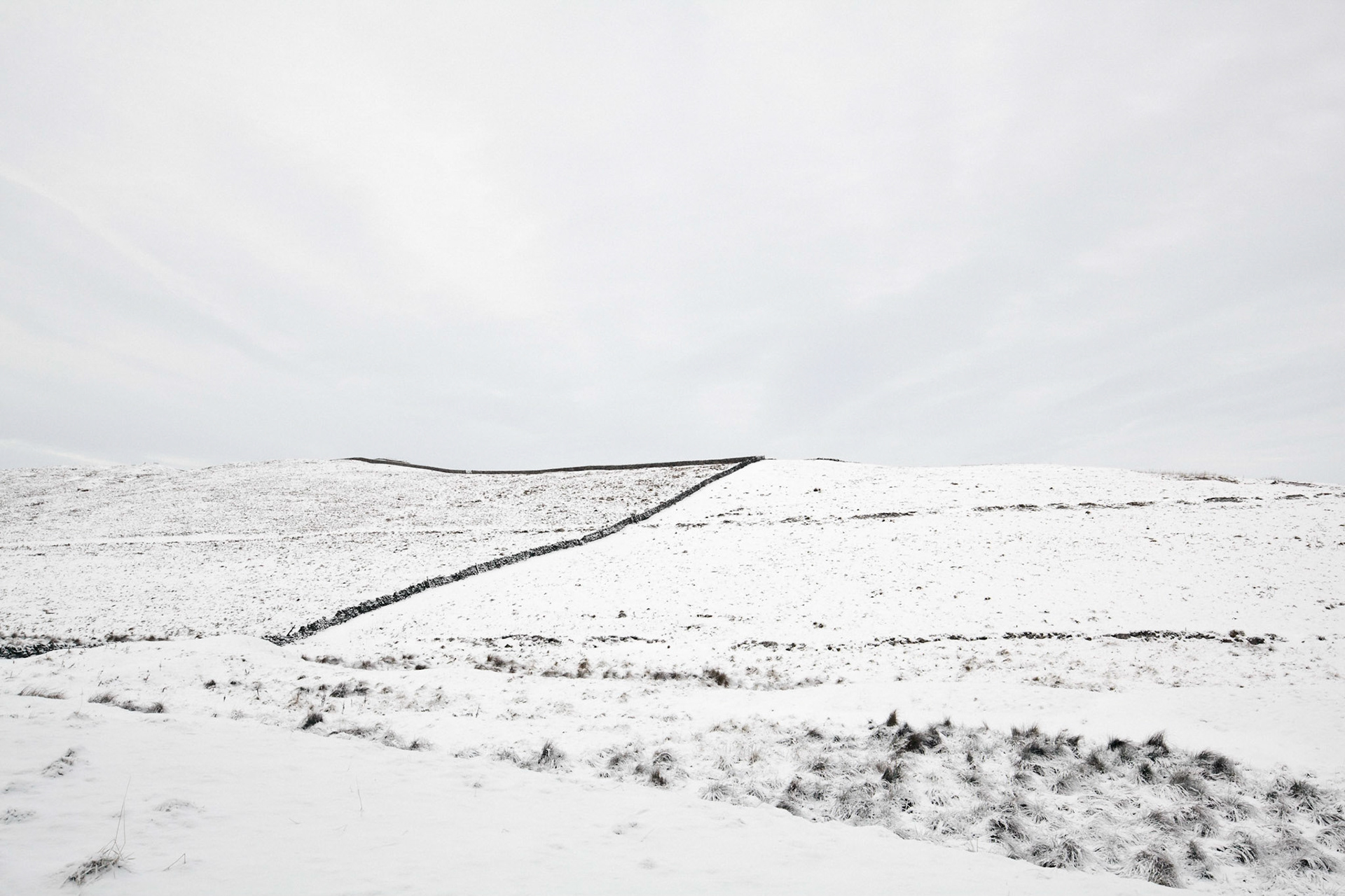 Northumberland National Park in England covered in thick snow on an overcast day