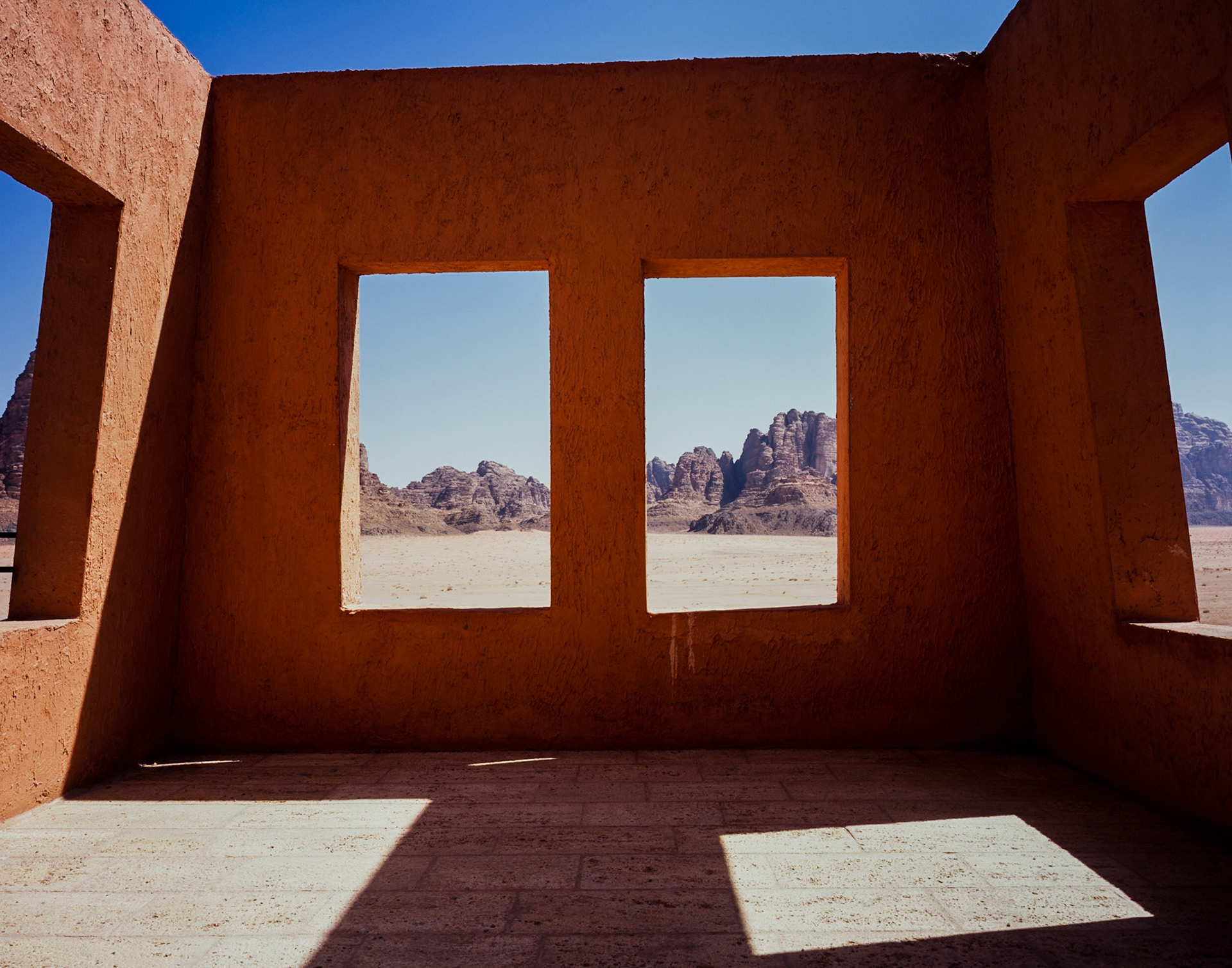 Terracotta coloured building with no roof in Wadi Rum, Jordan, Middle East, with desert landscape showing through windows