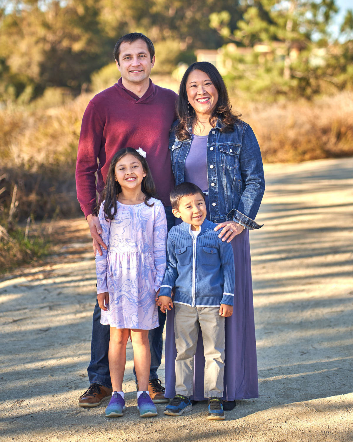 Family standing together at sunset with golden sky