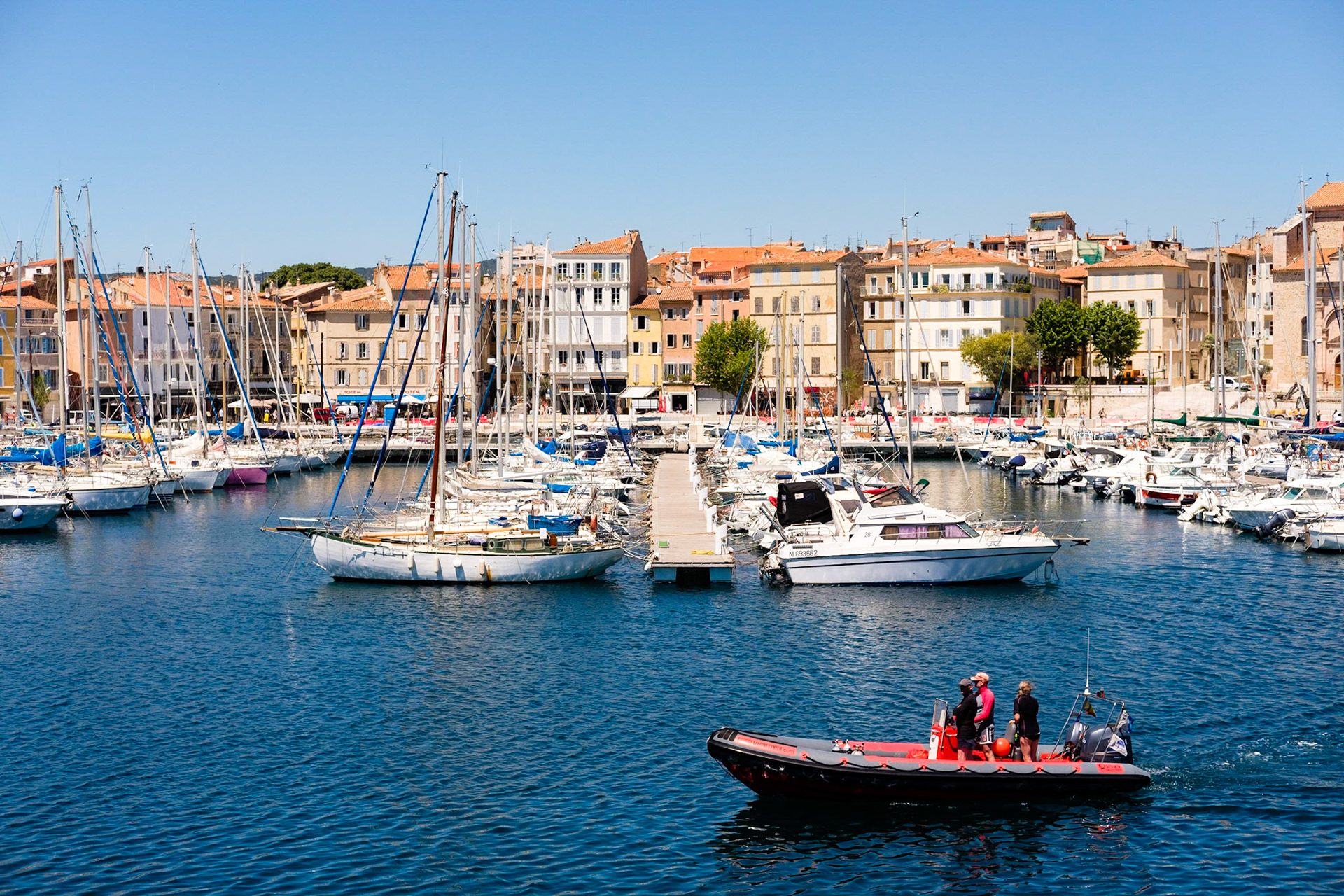Un zodiac dans le port de La Ciotat avec 3 personnes à bord.