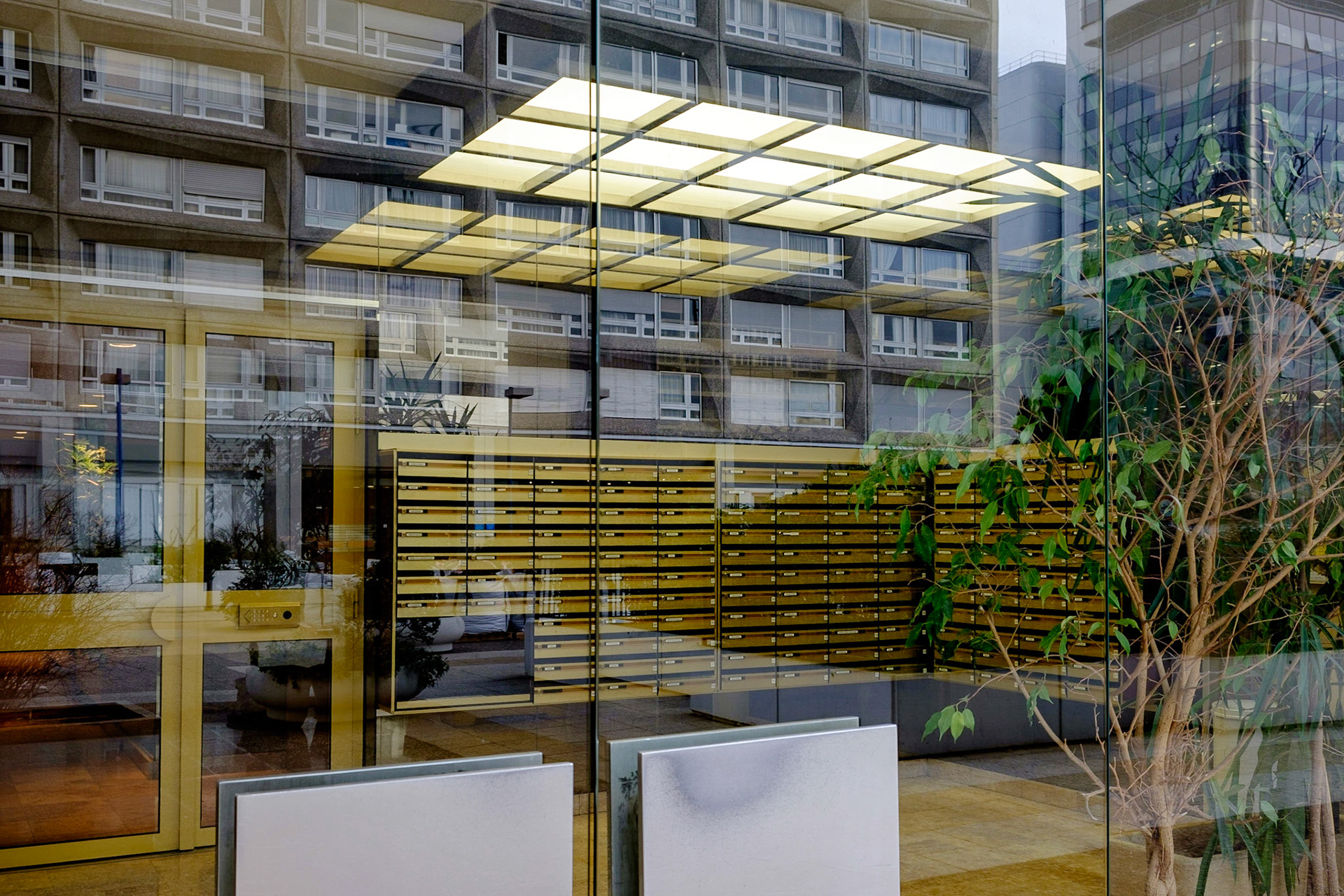 La Dalle Tolbiac, 13 ème arrondissement, Paris. Reflets d'immeubles dans la vitre d'un hall d'accueil. / The Dalle Tolbiac 13th arrondissement, Paris. Buildings reflections in a glass lobby