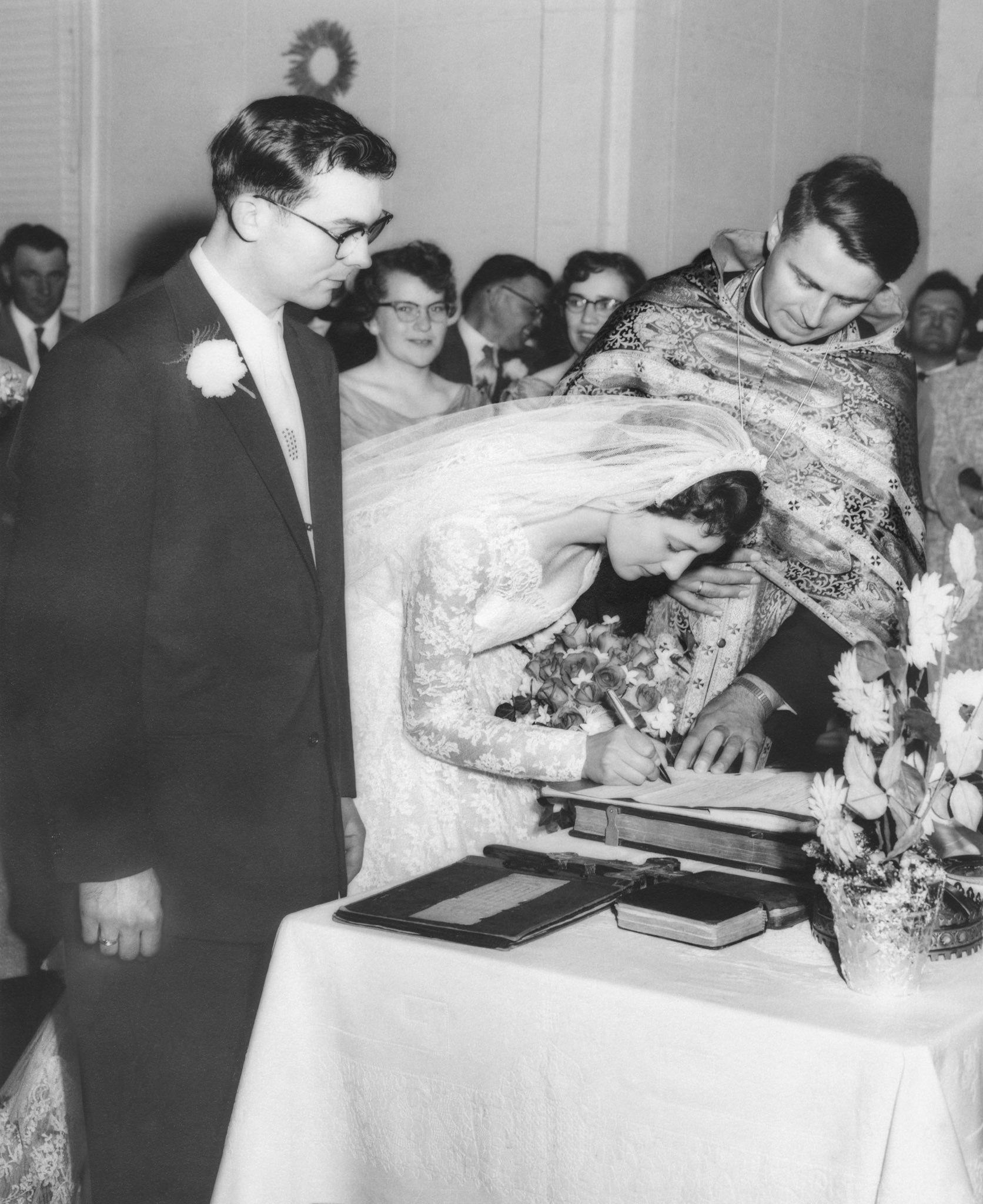 John Huculak, Kathleen [Shewchuk] Huculak, Rev Dmytro Luchak, signing the marriage certificate. Background Evelyn Shewchuk, Julia Kocak