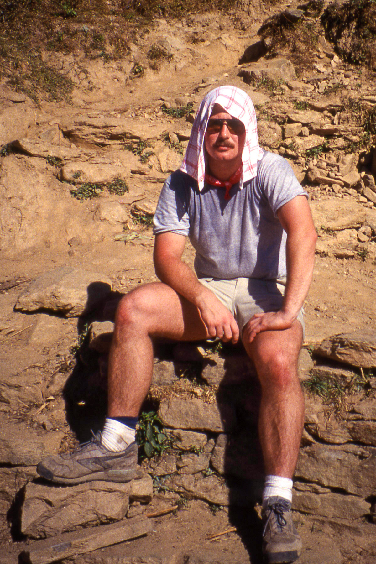 1992 Nepal: Yours truly (Brian Huculak) hanging out on the side of a trail, enroute to Kalapatar to see Everest. To say there was some heat at that altitude would be putting it mildly. Photo Credit: Robert Keith